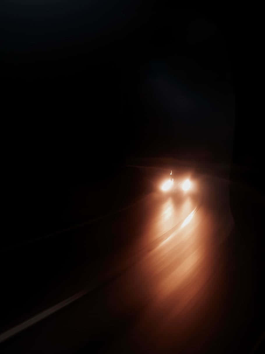 汽車頭燈照亮黑暗隧道內的潮濕道路。