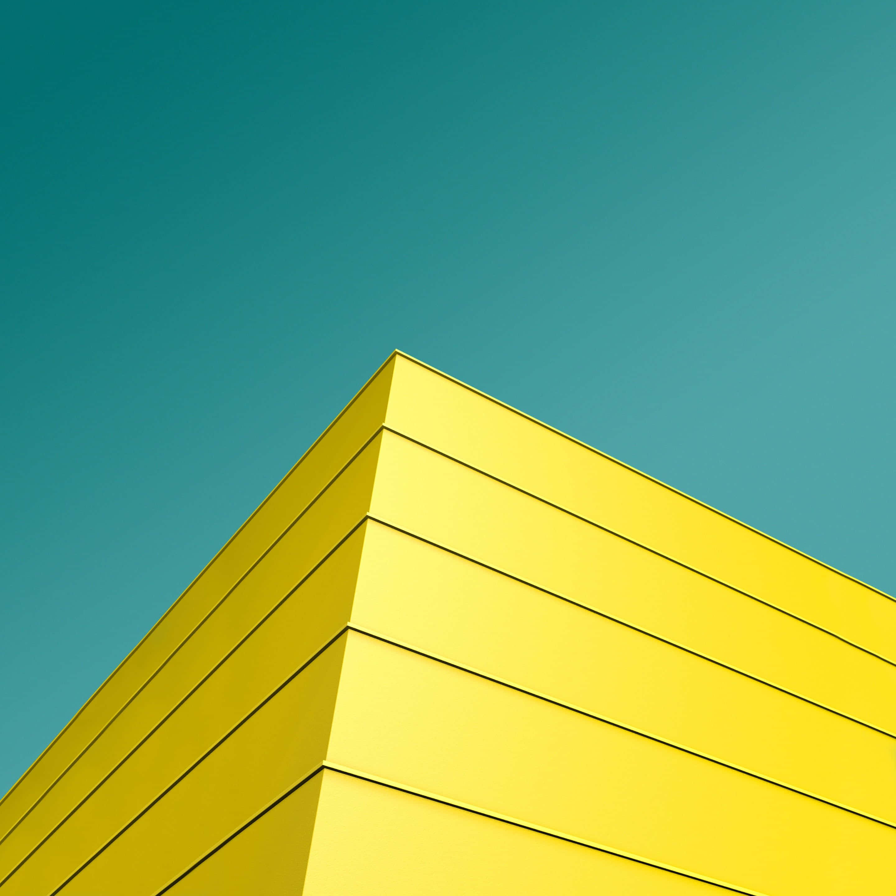 Yellow Geometric 桌布 壁紙 — 大膽的黃色建築角落與清澈的青綠色天空形成鮮明對比，呈現極簡主義建築風格。