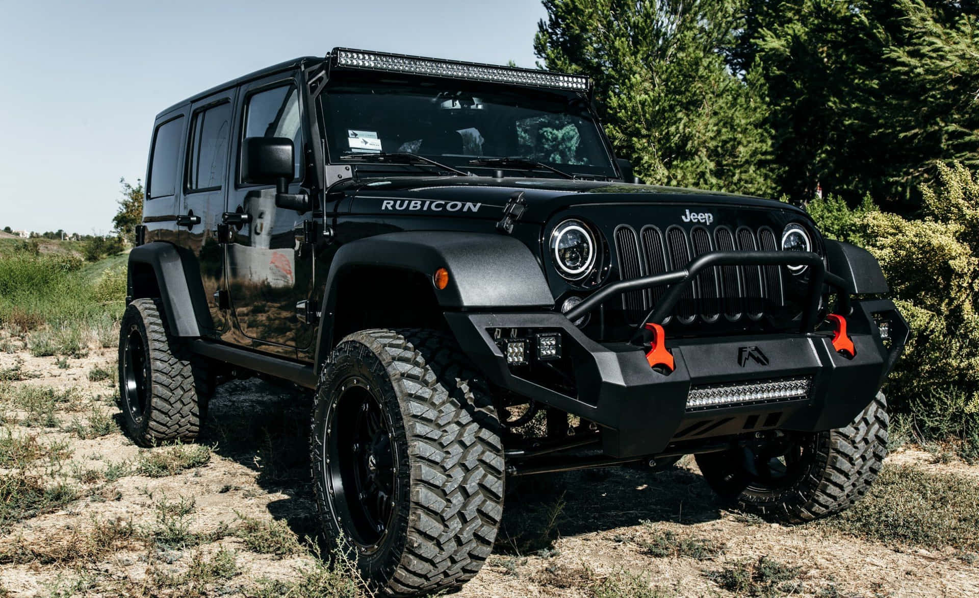 帶有橙色救援點的黑色Jeep Rubicon停在乾草上。