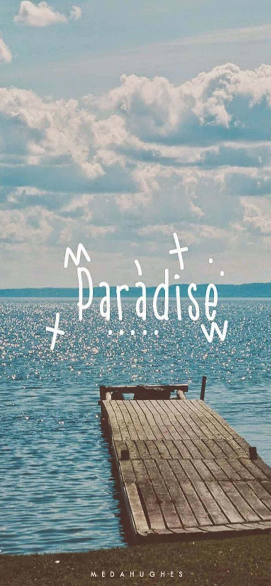 木碼頭伸入平靜的藍色水中，多雲的天空下帶有'Paradise'文字。