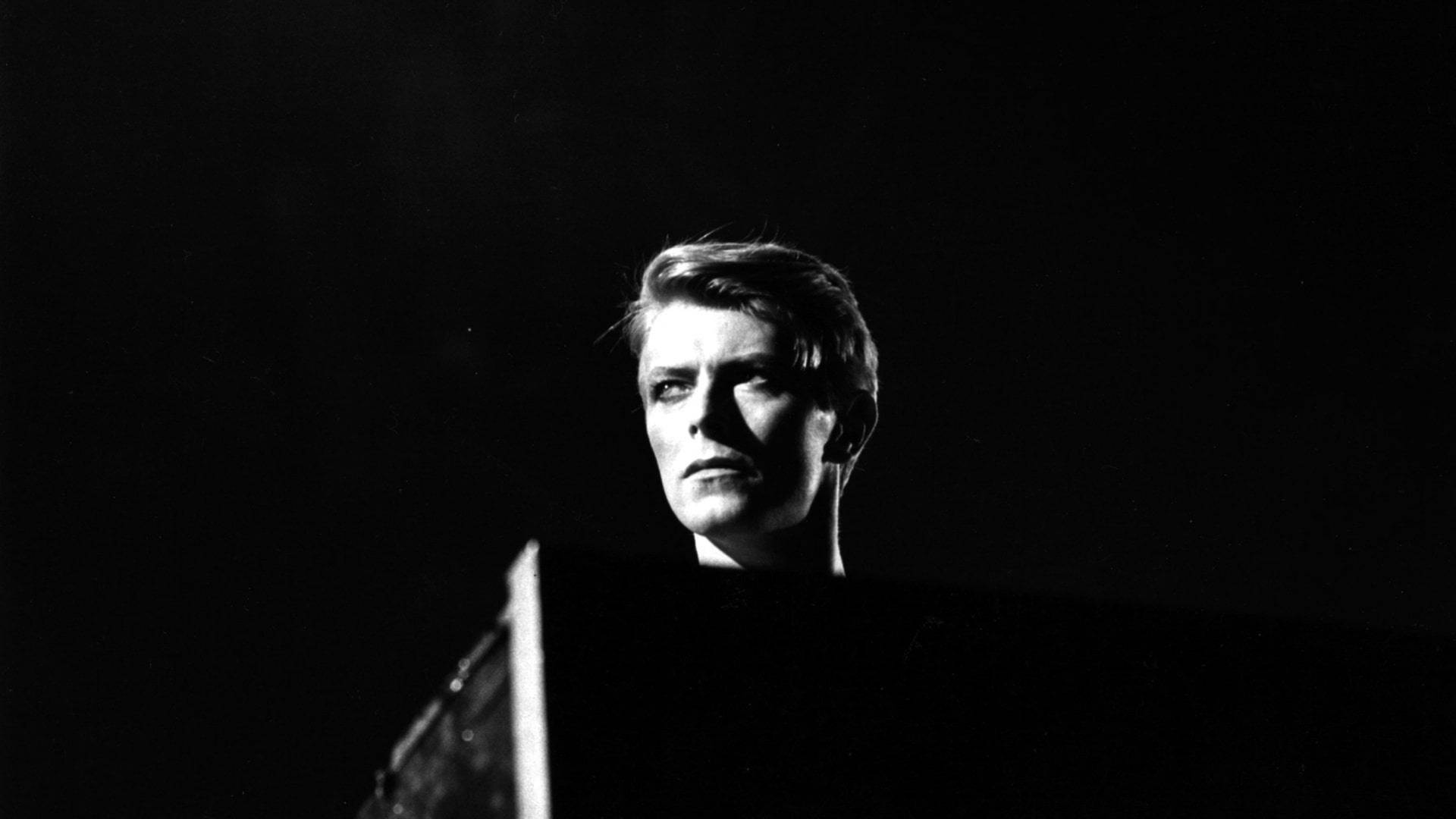 Davies Bowie 的戲劇性黑白舞台肖像，眼神強烈。
