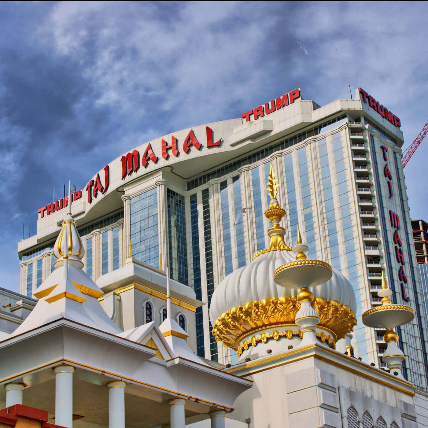 大西洋城特朗普泰姬陵酒店 壁紙 — 宏偉的Trump Taj Mahal酒店，金色圓頂和玻璃外牆，天空多雲。