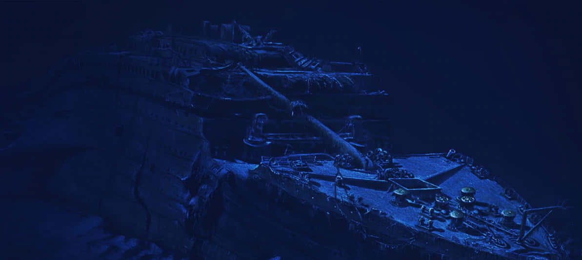 一艘沉沒的遠洋客輪在深藍色海水中破碎地躺在海底。
