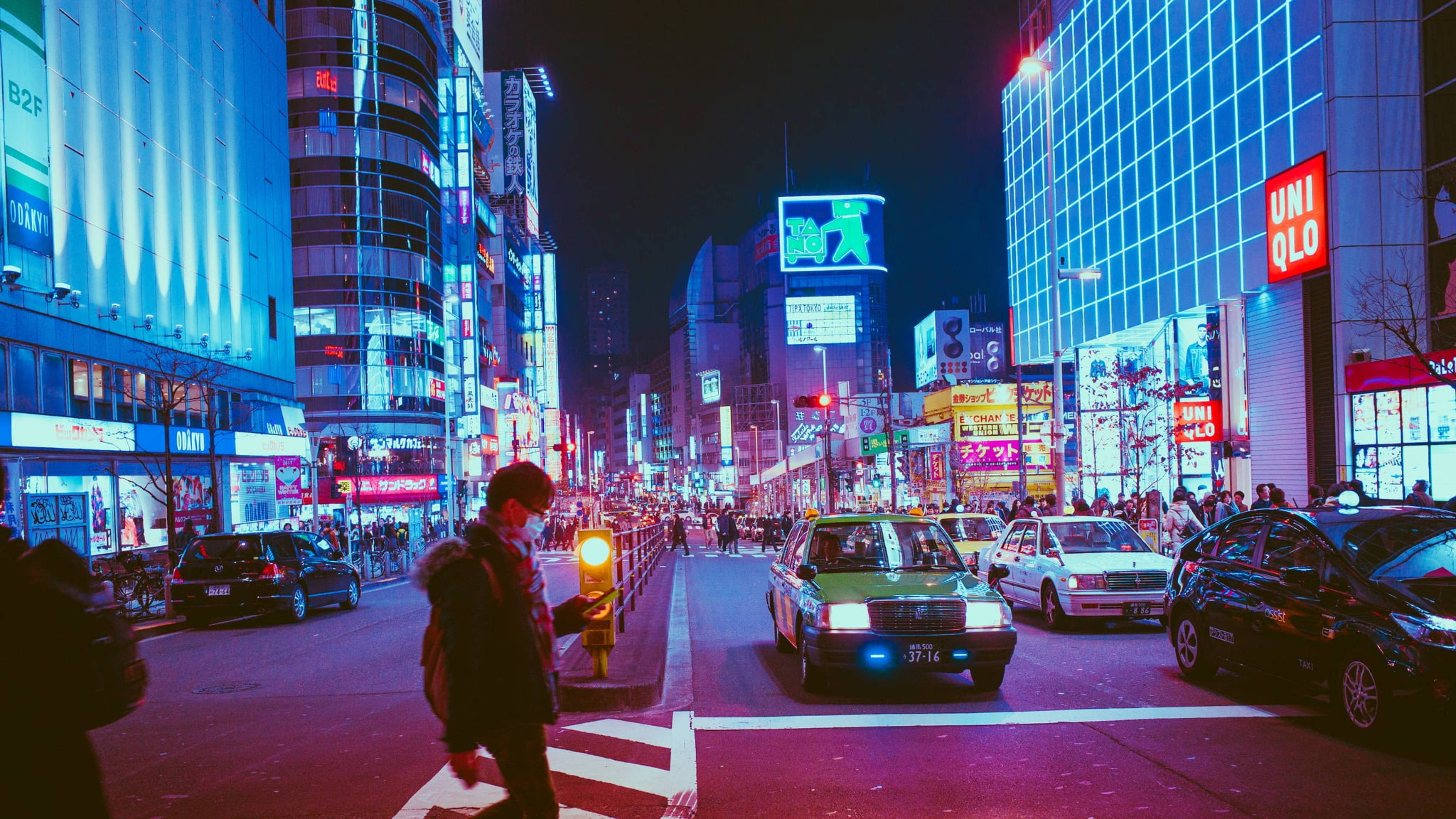 大阪夜景 壁紙 — 充滿活力的霓虹燈東京夜晚街道，有發光的廣告牌、的士和行人穿過繁忙的十字路口。