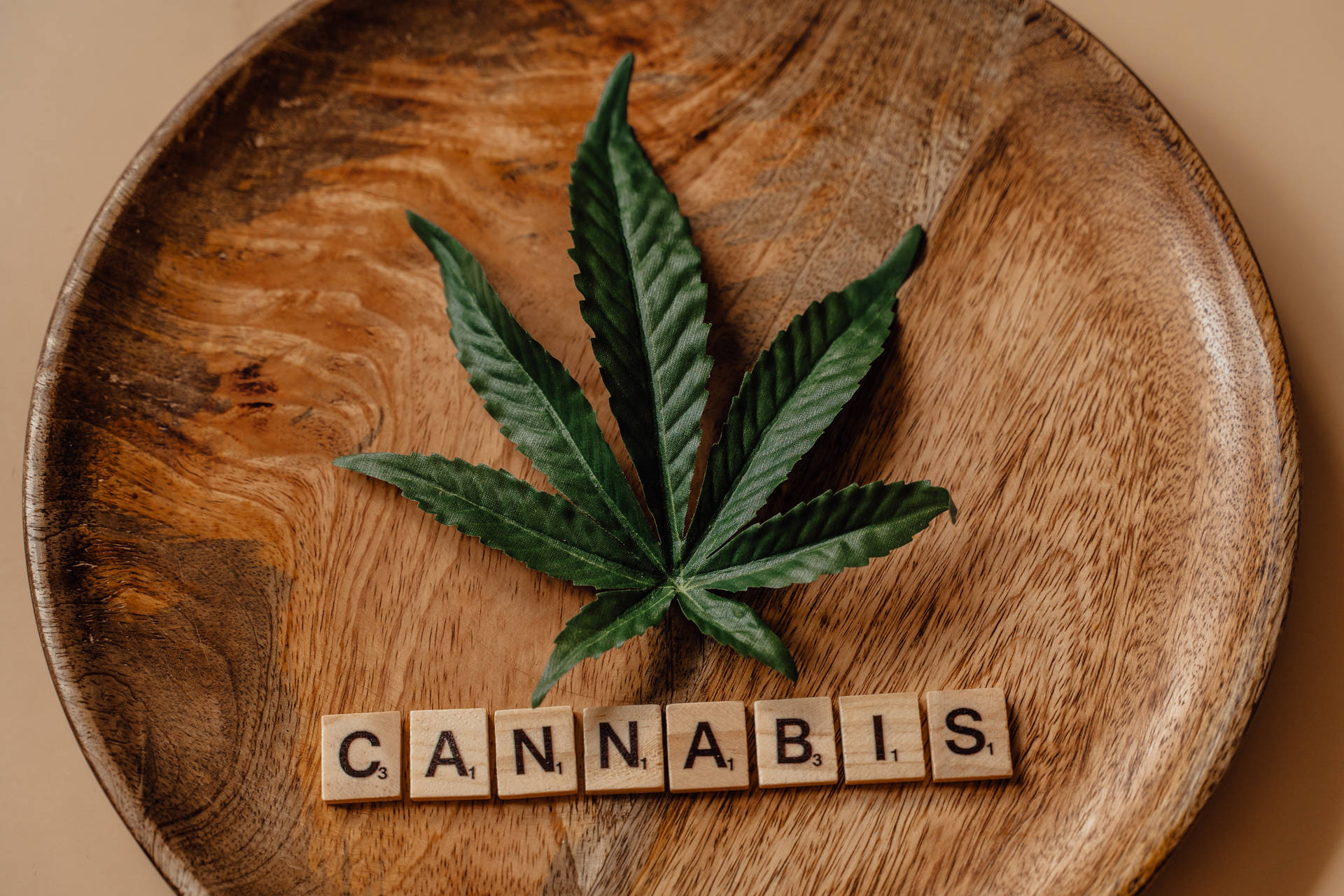 木盤上的大麻葉和拼出cannabis的拼字磚。