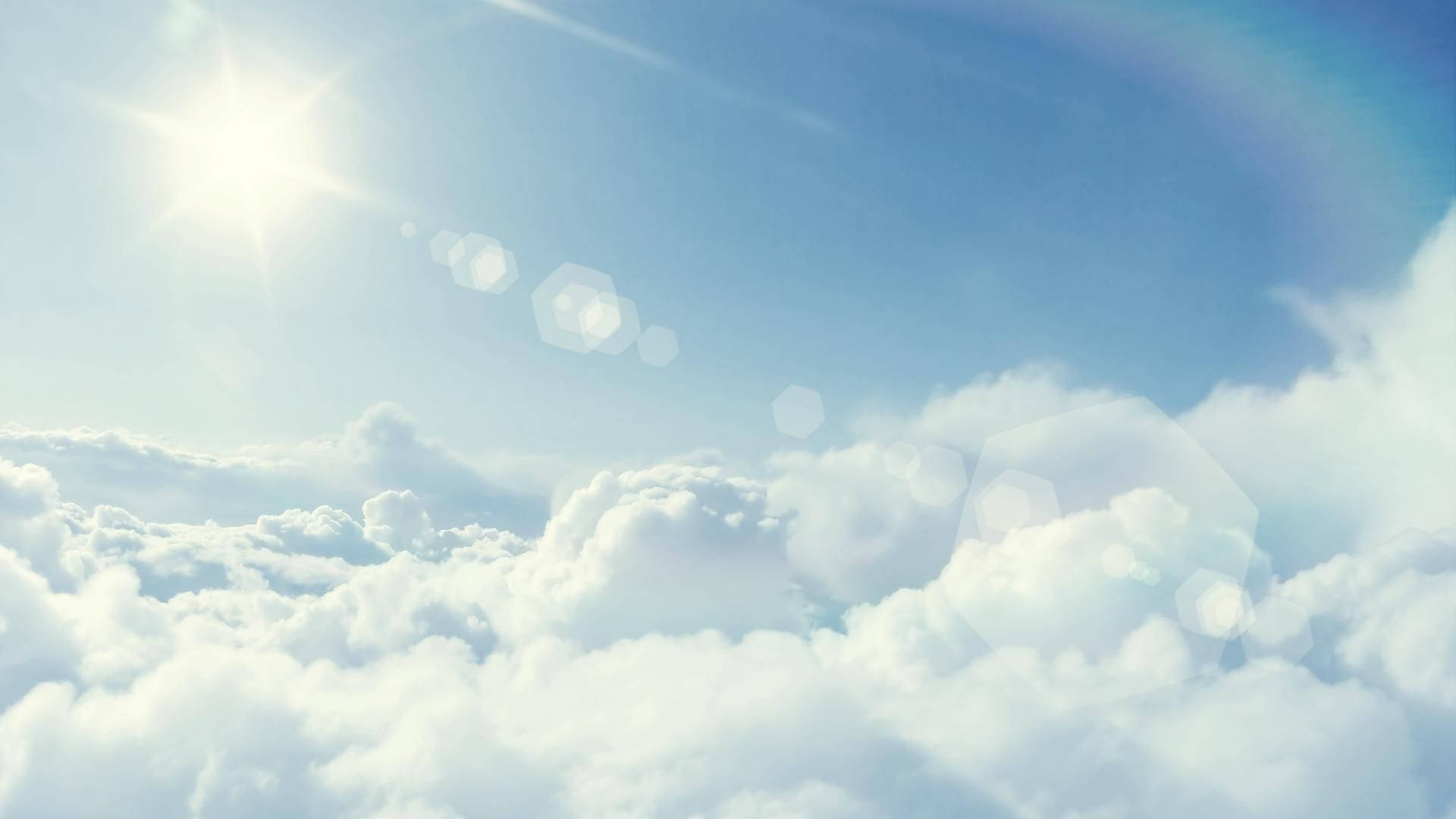 陽光穿過蓬鬆的雲層，在清澈的藍天上形成鏡頭光暈。