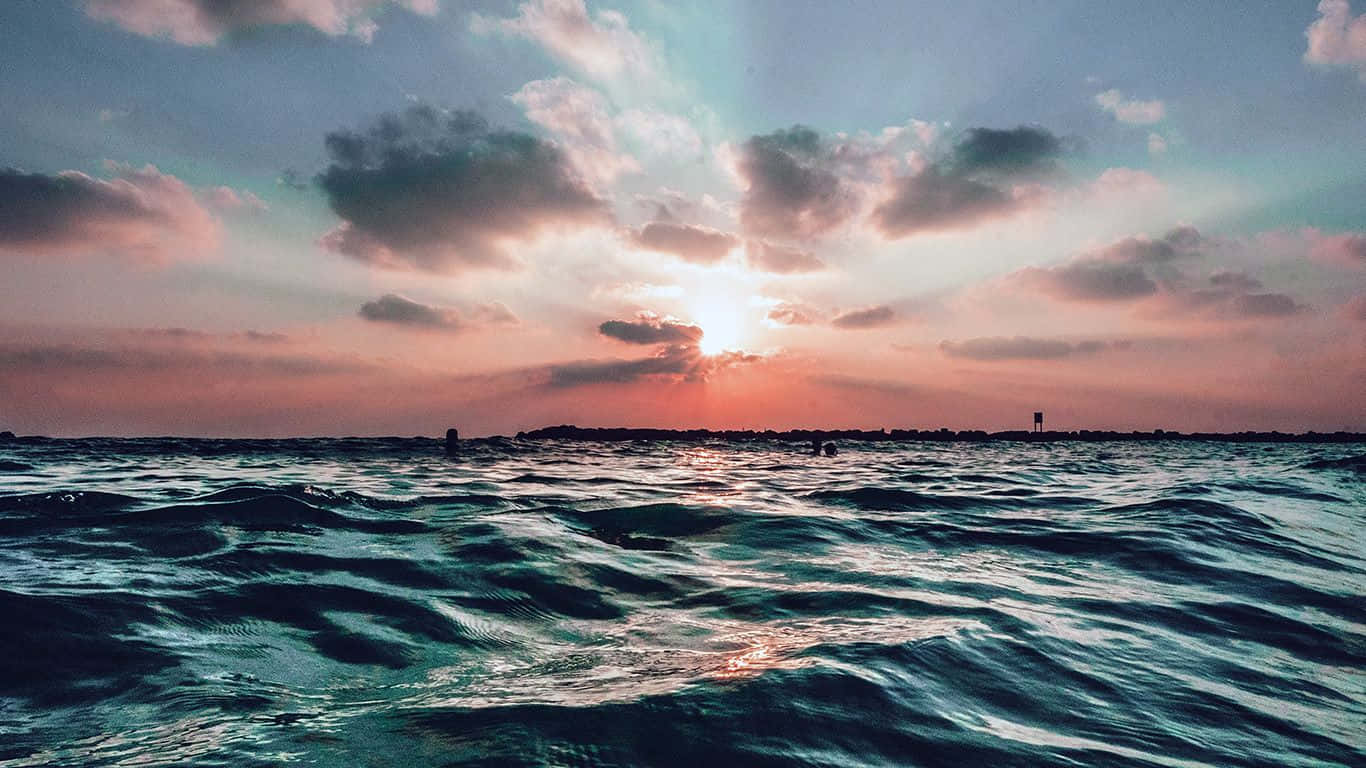 海洋上的夕陽，有雲和遠處陸地