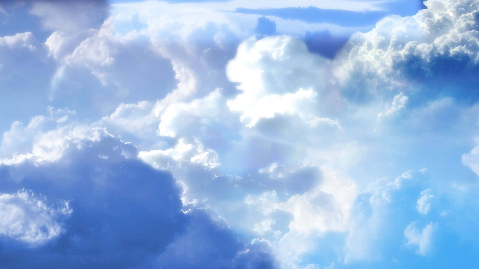 天堂般的寧靜天空與飄浮雲朵 壁紙 — 廣闊的藍天充滿了蓬鬆的白雲，被明亮的陽光照射，形成柔和的陰影和空靈的光芒。