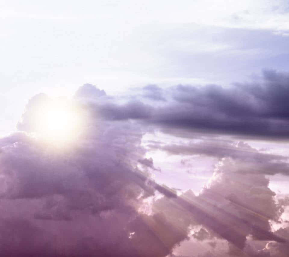 天堂雲朵：寧靜與奇觀的交融 壁紙 — 陽光穿透紫色雲層，在夢幻般的天空中投射出耀眼的光芒。