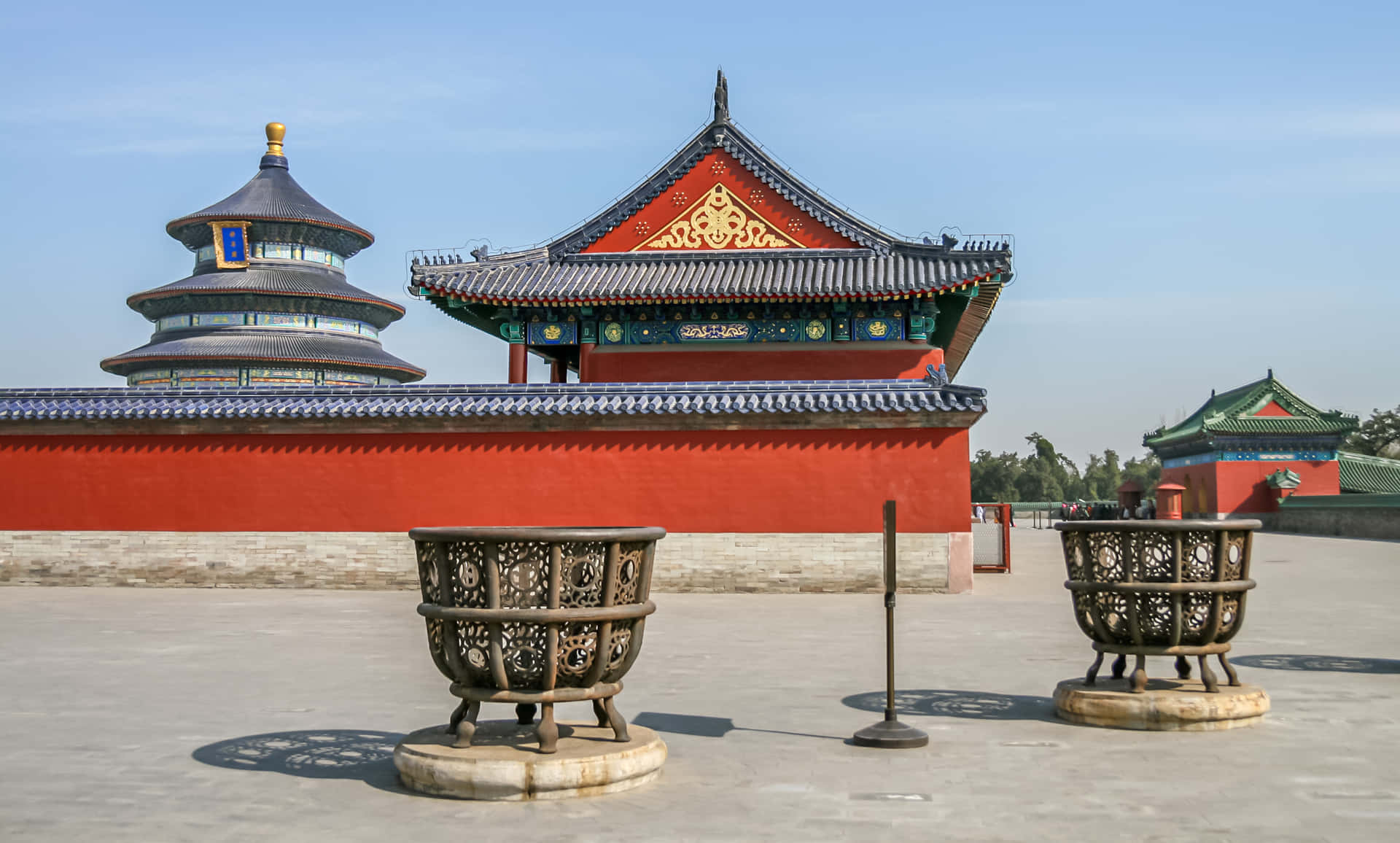 紅牆中式寺廟建築群，華麗屋頂和儀式用香爐。