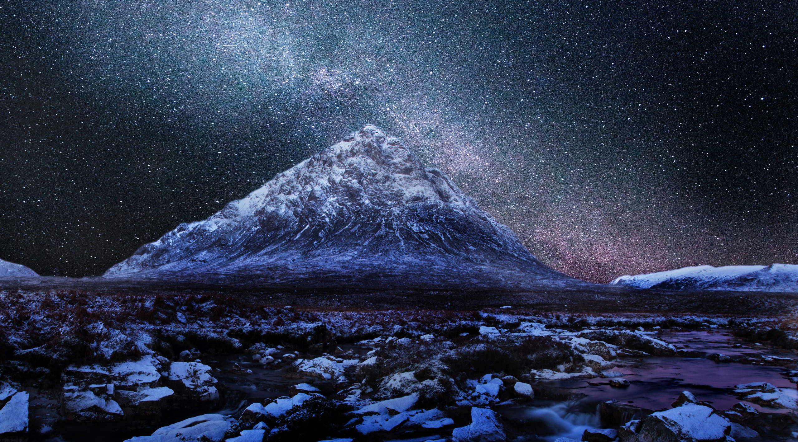 天文攝影雪山夜景 壁紙 — 一座積雪的山峰在繁星點點的冬夜天空下，在燦爛的銀河系下方升起。