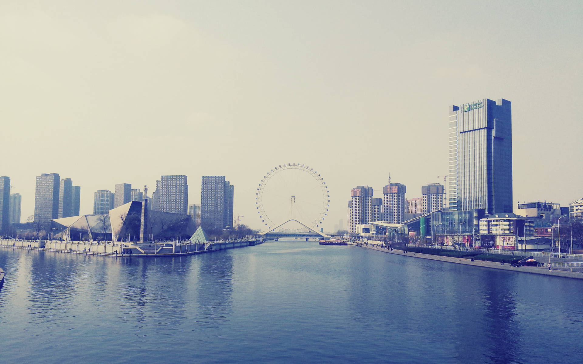 城市天際線，河流和摩天輪在朦朧的天空下