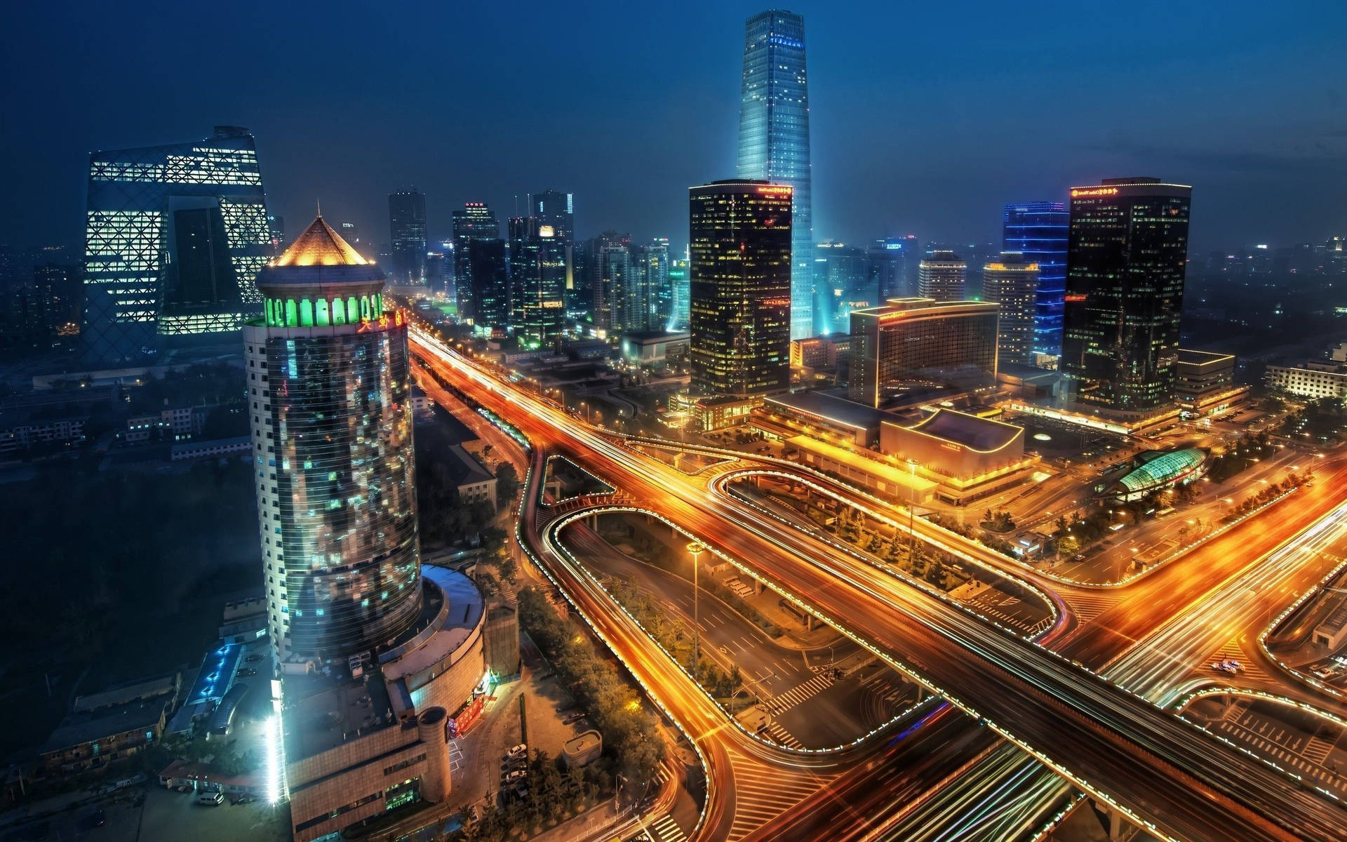 夜晚的城市景觀，摩天大樓燈火通明，車流光軌閃爍。