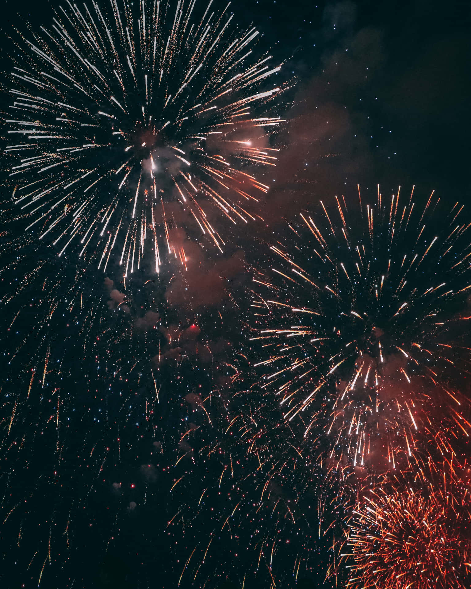 煙花以明亮的爆發和煙霧痕跡照亮夜空。