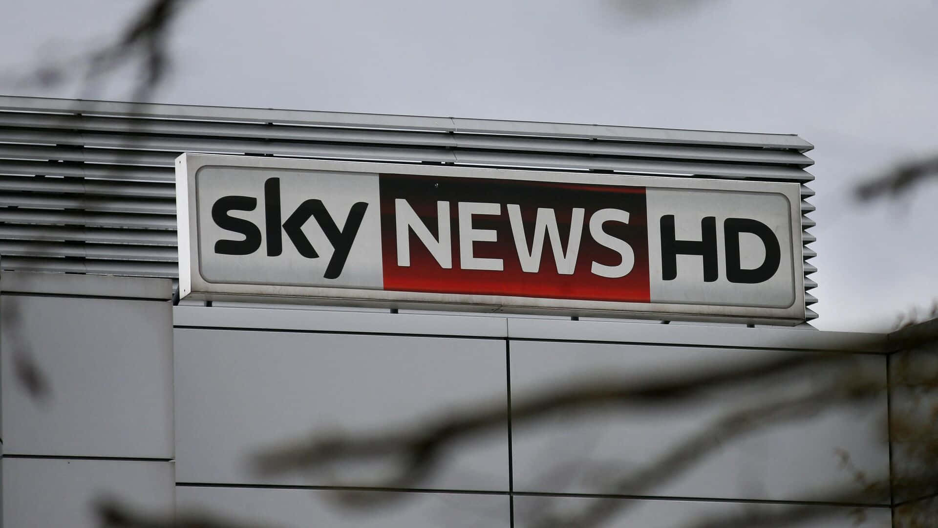 建築物上的 Sky News HD 標誌，前面有樹枝。
