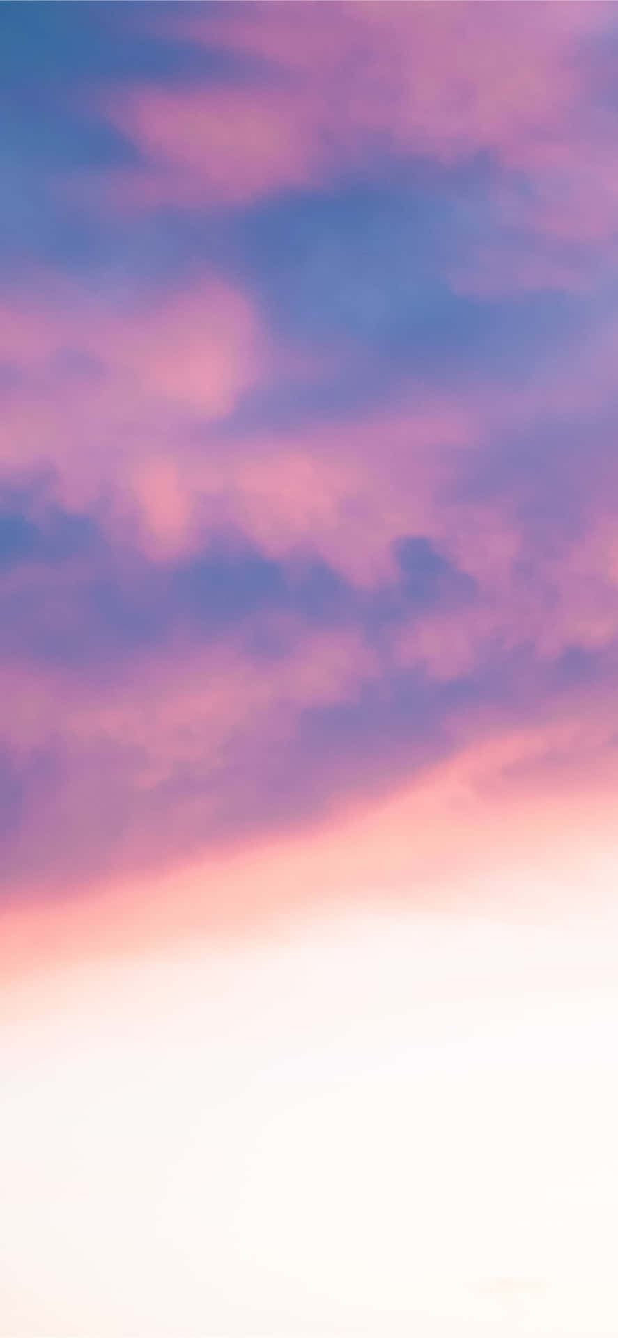 日落時分明亮地平線上的粉彩粉紅色和紫色雲彩。