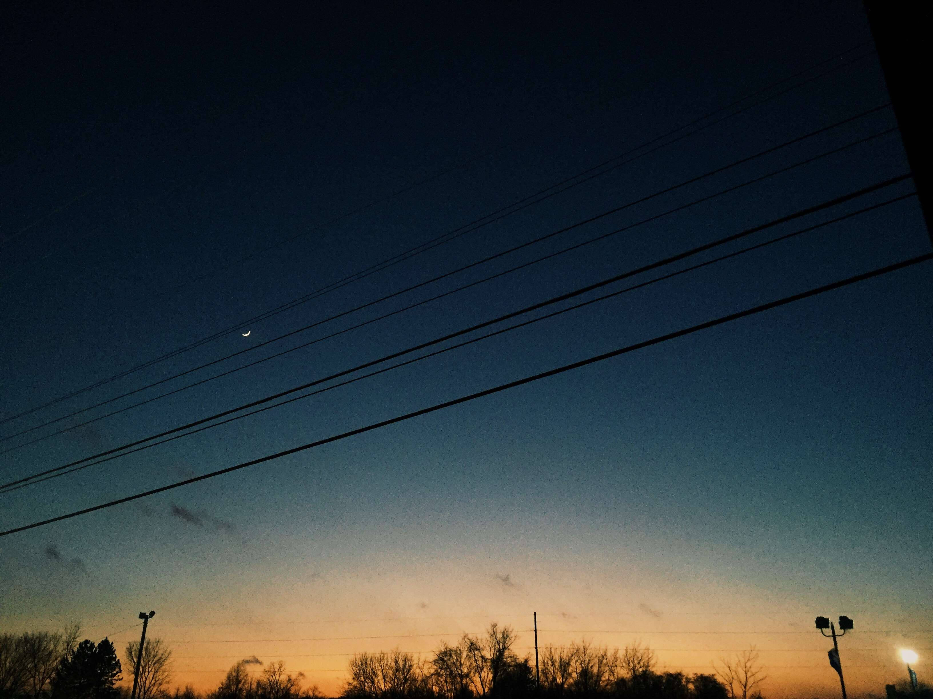 天空與夕陽 VSCO 背景 壁紙 — 一彎新月掛在電線上，襯托著從橙色漸變為深藍色的暮色天空。