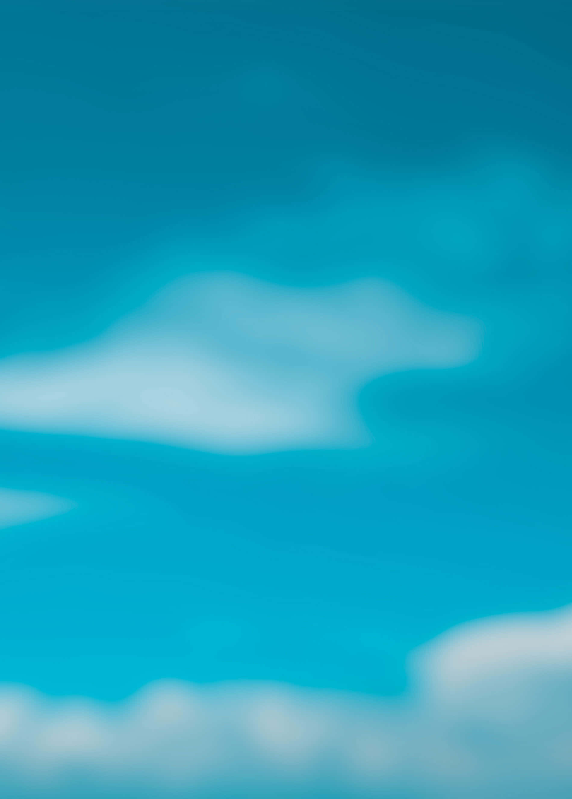天藍背景漸變色彩 壁紙 — 柔和模糊的雲朵在充滿活力的青綠色天空中飄移，營造出夢幻寧靜的氛圍。
