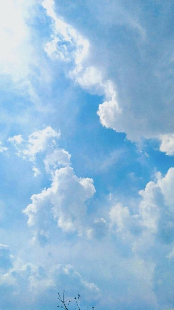 天藍雲朵美學 壁紙 — 廣闊藍天佈滿蓬鬆白雲，柔和陽光穿過縷縷雲層。
