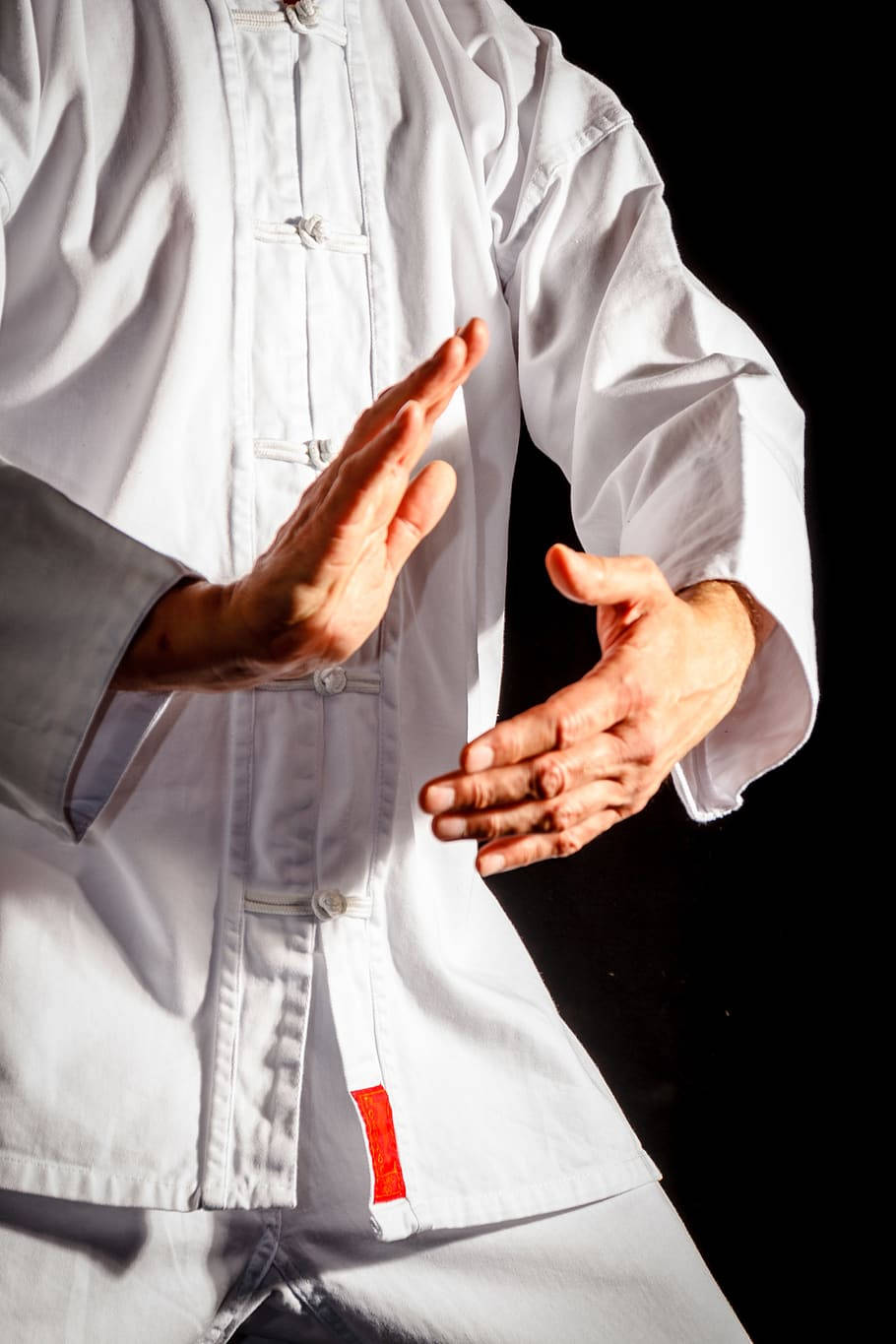 身穿白色武術制服的人士在攝影棚內做出手勢