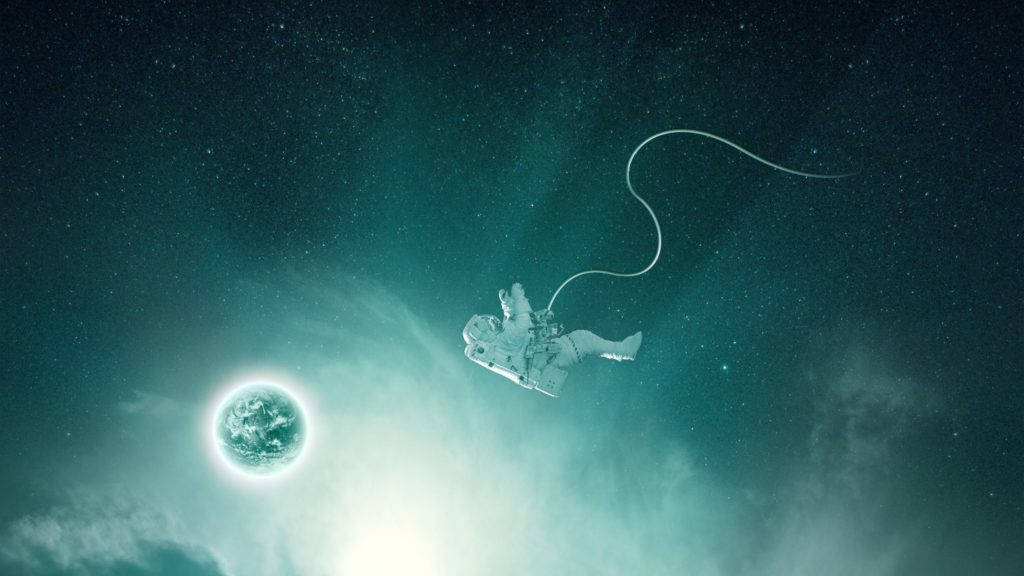 太空中的漂浮宇航員 壁紙 — 一名太空人漂浮在藍綠色太空，連接到一個散發明亮光環的行星。