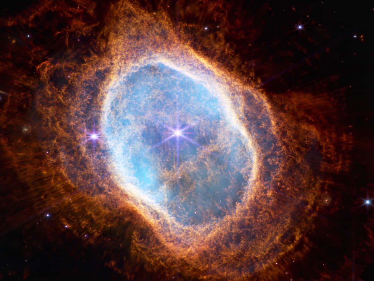 太空天文學：南環星雲 壁紙 — 一個令人驚嘆的宇宙星雲，中心明亮藍色，周圍環繞著熾熱的橙色卷鬚，背景是繁星點點的黑色虛空。