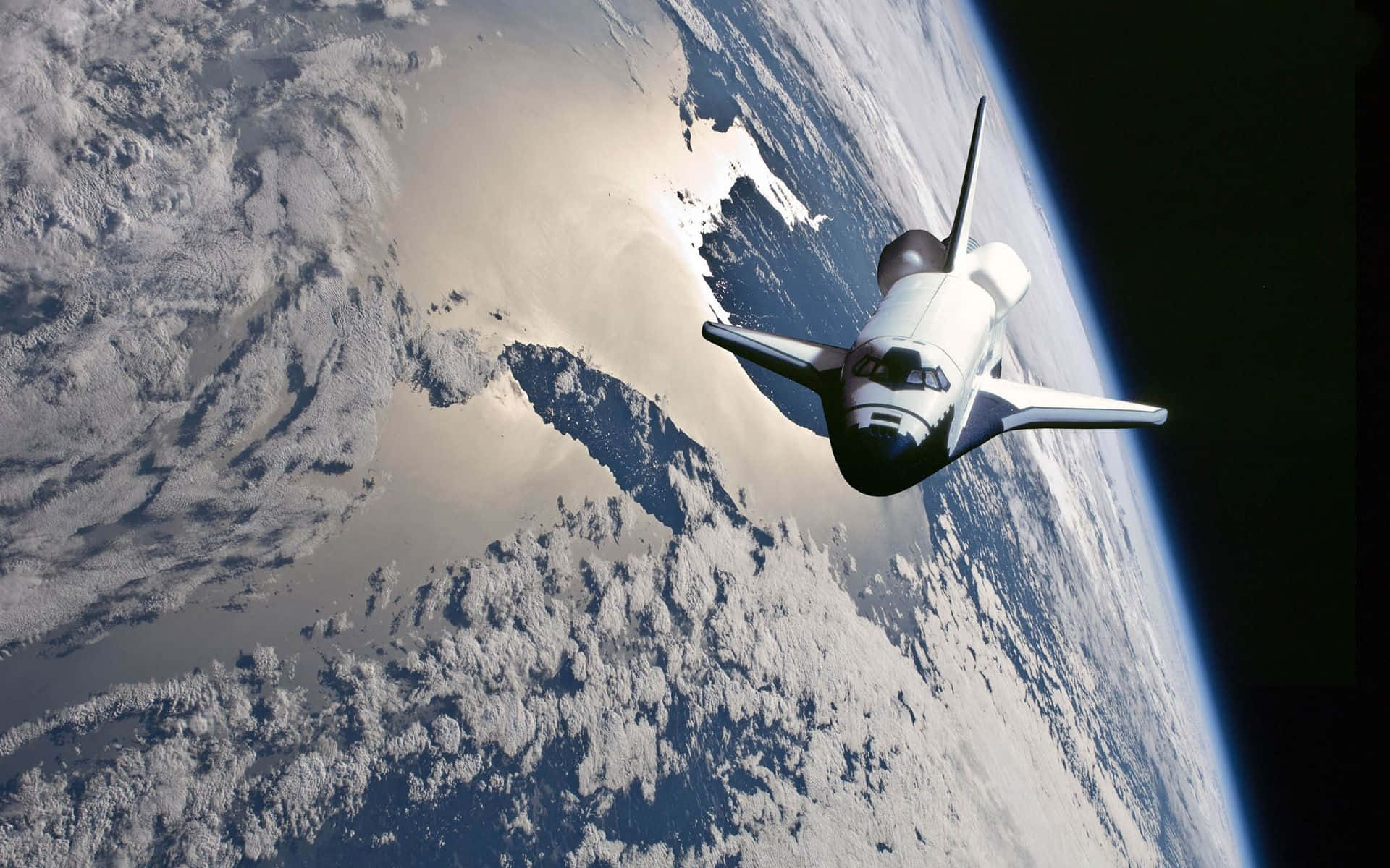 太空穿梭機繞地球軌道運行，顯示下方的雲層和海洋