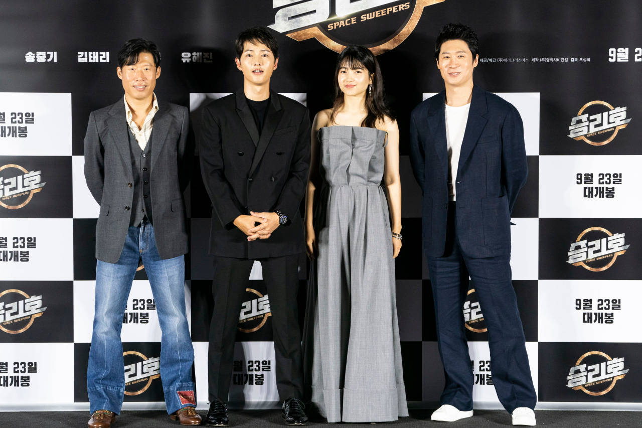 太空清道夫主角群 壁紙 — 四位演員在電影首映禮上正式擺姿勢，背景為格子圖案，帶有韓文文字和片名《Space Sweepers》。