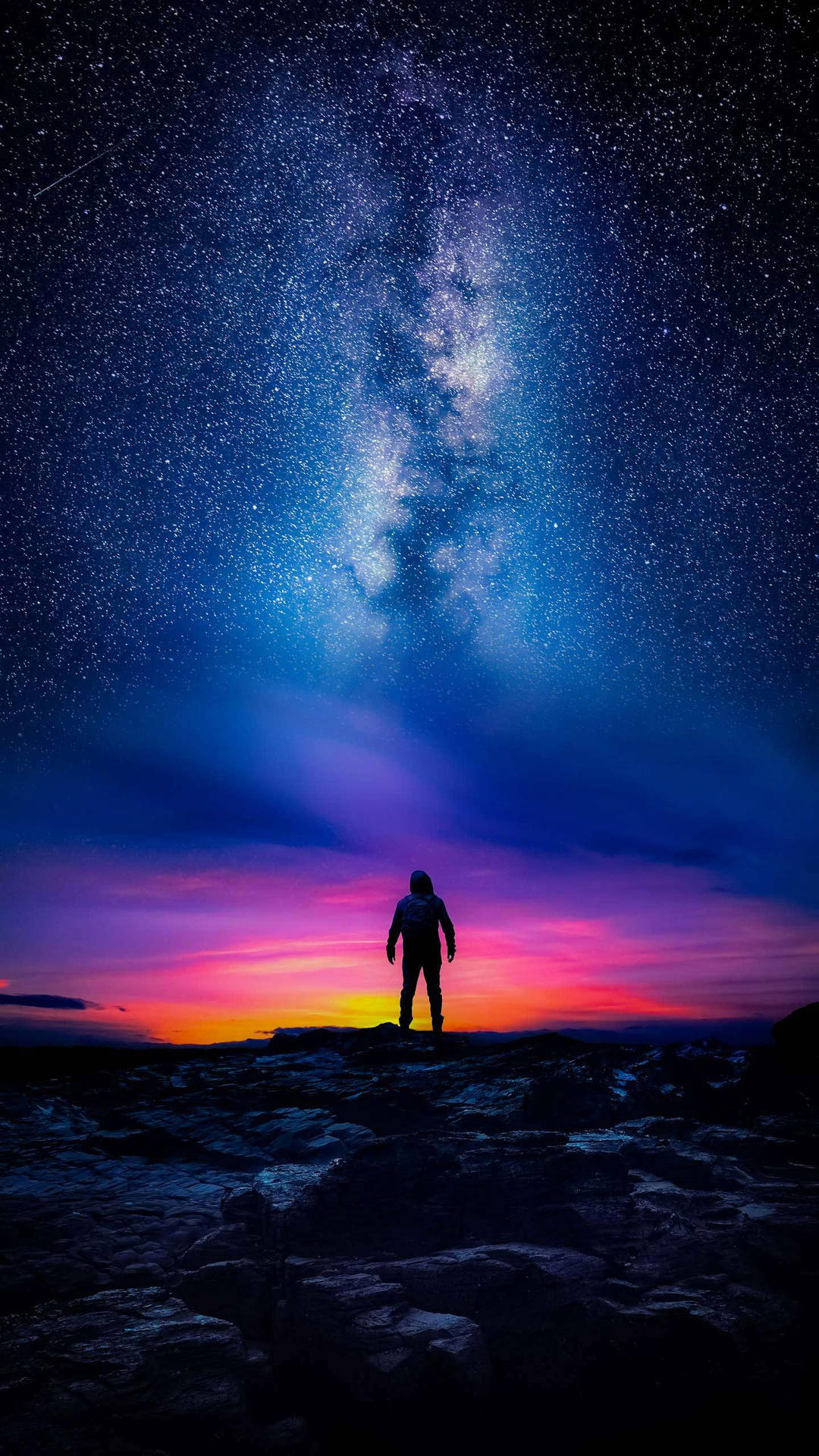 人站在岩石上，星空下，銀河可見