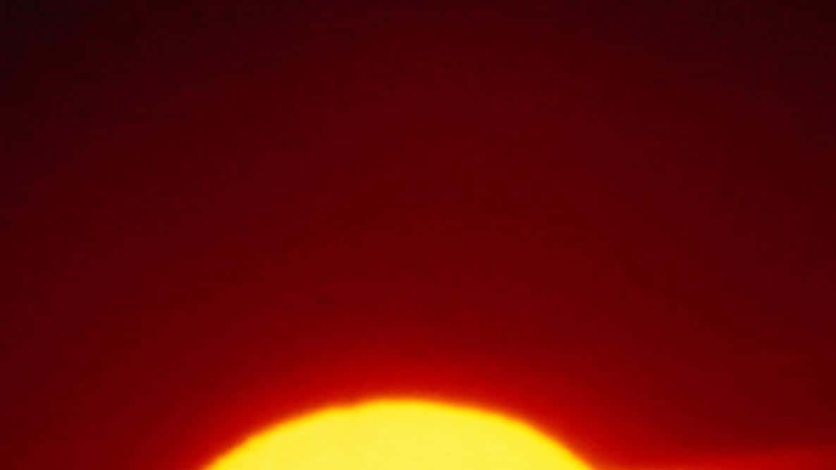 一輪發光的太陽在火紅的天空中落下。