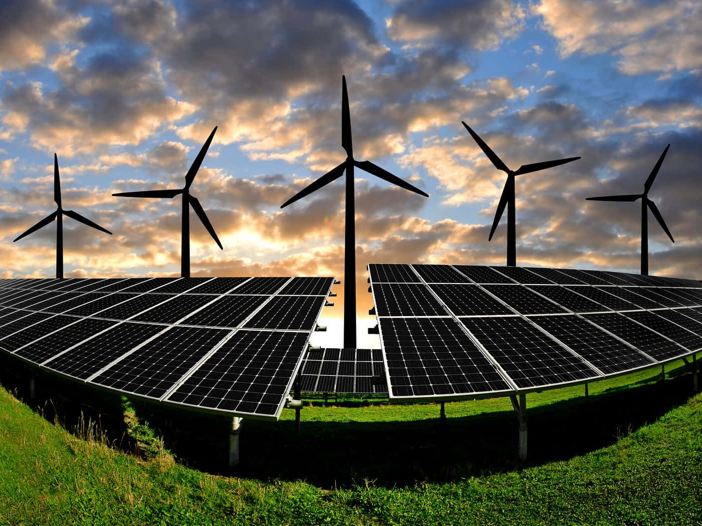 Energy 桌布 壁紙 — 太陽能板和風力發電機在金色雲彩的戲劇性日落天空下形成剪影。