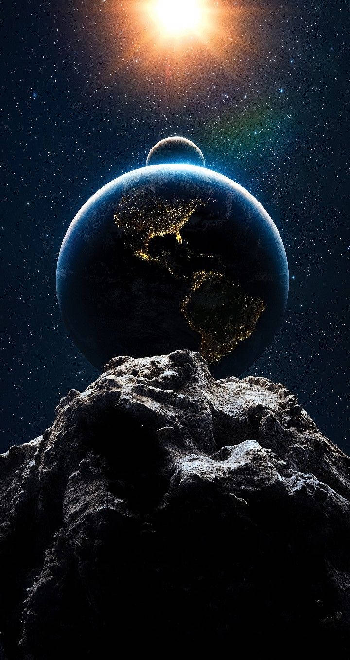 太陽與月亮與小行星 壁紙 — 一顆發光的地球，城市燈光點綴其上，坐落於崎嶇的小行星上，下方是璀璨的太陽，背景是繁星點點的宇宙虛空。