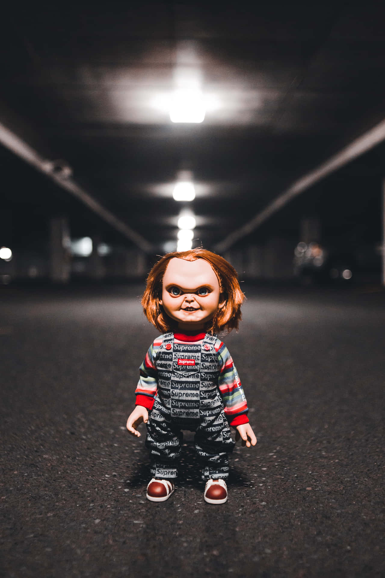 Chucky 娃娃穿著 Supreme 衣服，夜晚站在黑暗的隧道中。