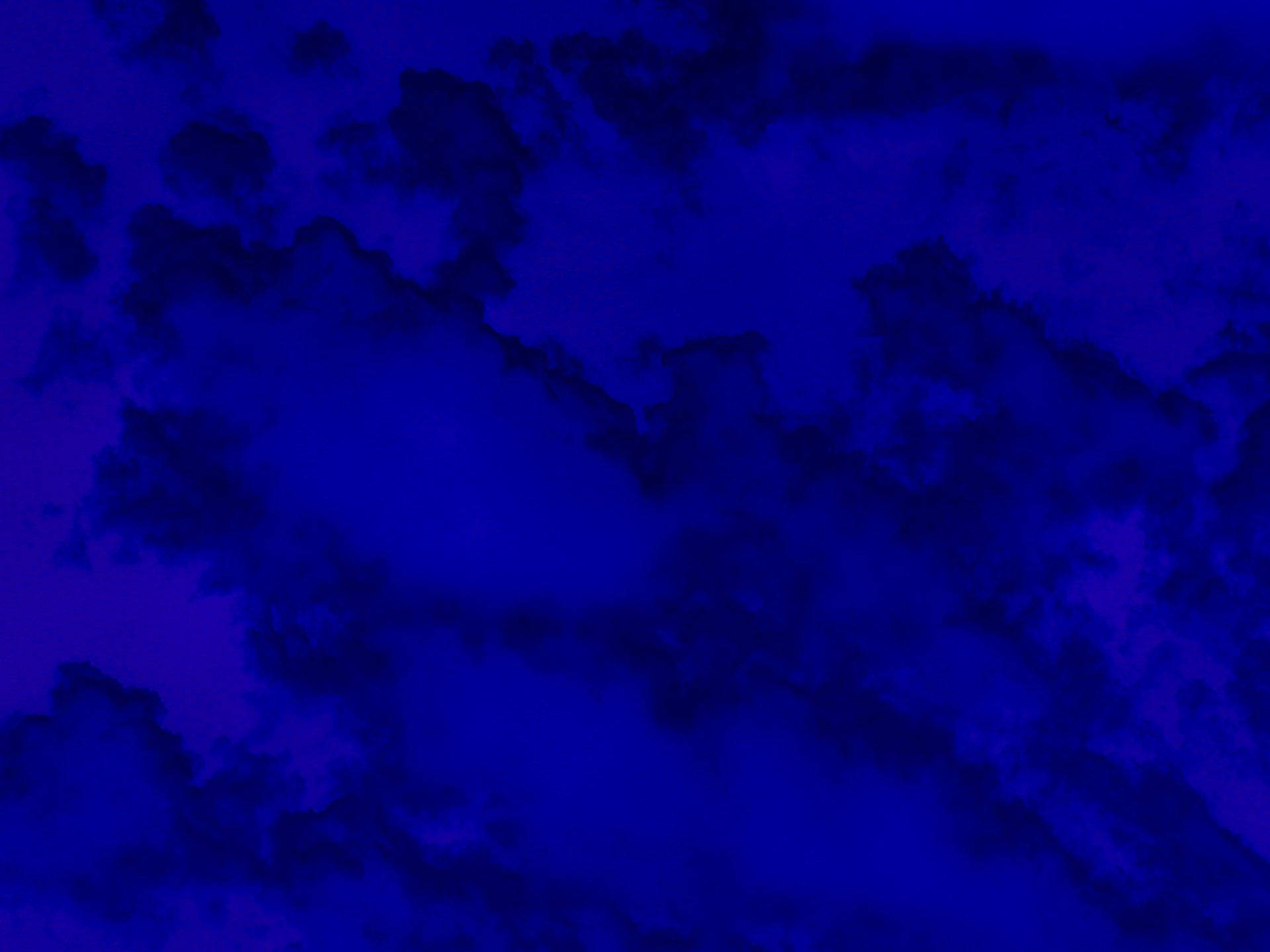 在夜空背景下，深藍色和紫色色調的戲劇性漩渦狀雲朵。