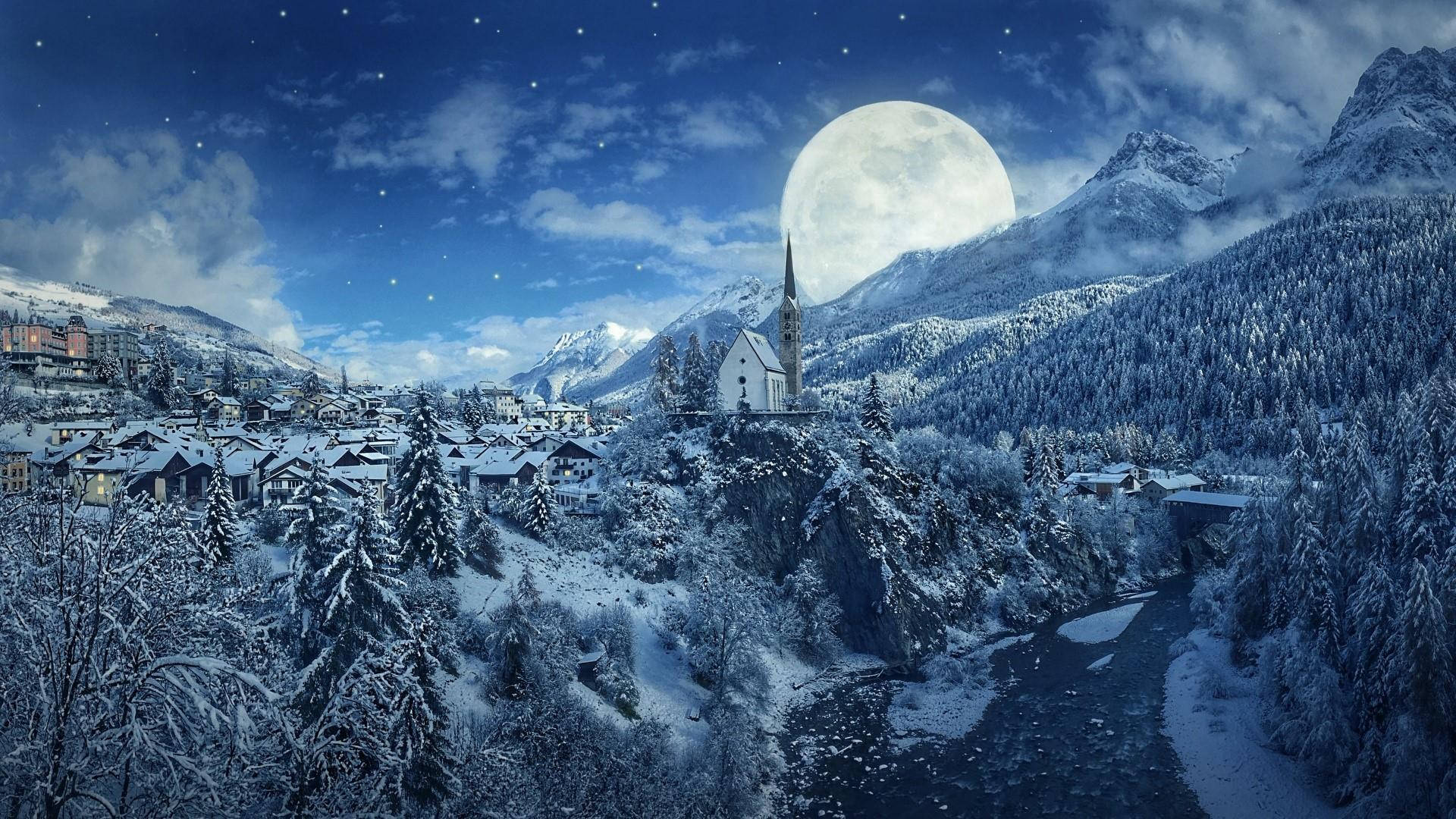 奇幻滿月冬日風景 壁紙 — 在深藍色夜空下，一個被雪覆蓋的山村，上方有巨大的月亮、星星和雲朵。