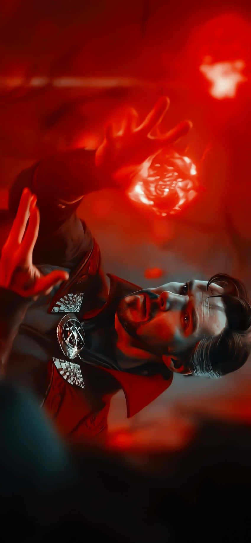 奇异博士冒險探索《多元宇宙的疯狂》 壁紙 — 一個穿著紅色斗篷的男人在深紅色背景前，透過雙手引導發光的紅色能量。