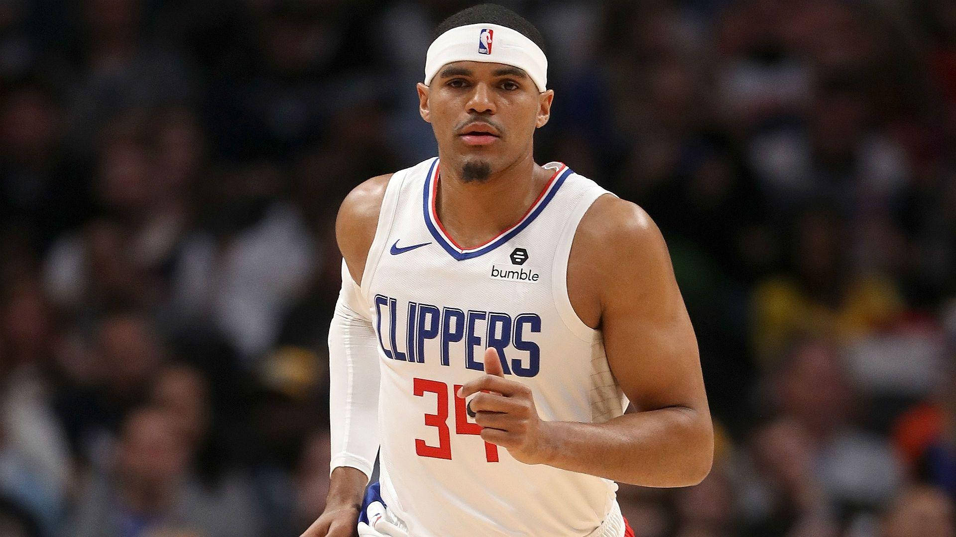 奔跑中的托拜厄斯·哈里斯NBA球員快艇隊 壁紙 — 一名專注的籃球運動員身穿白色快艇隊球衣，號碼34，在明亮的場館燈光下比賽中奔跑。