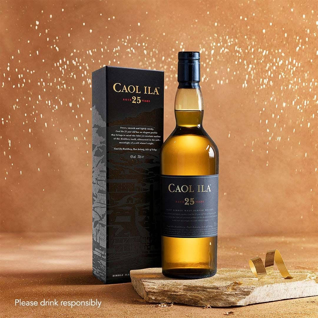 一瓶Caol Ila 25年威士忌連同其盒子放在木板上。
