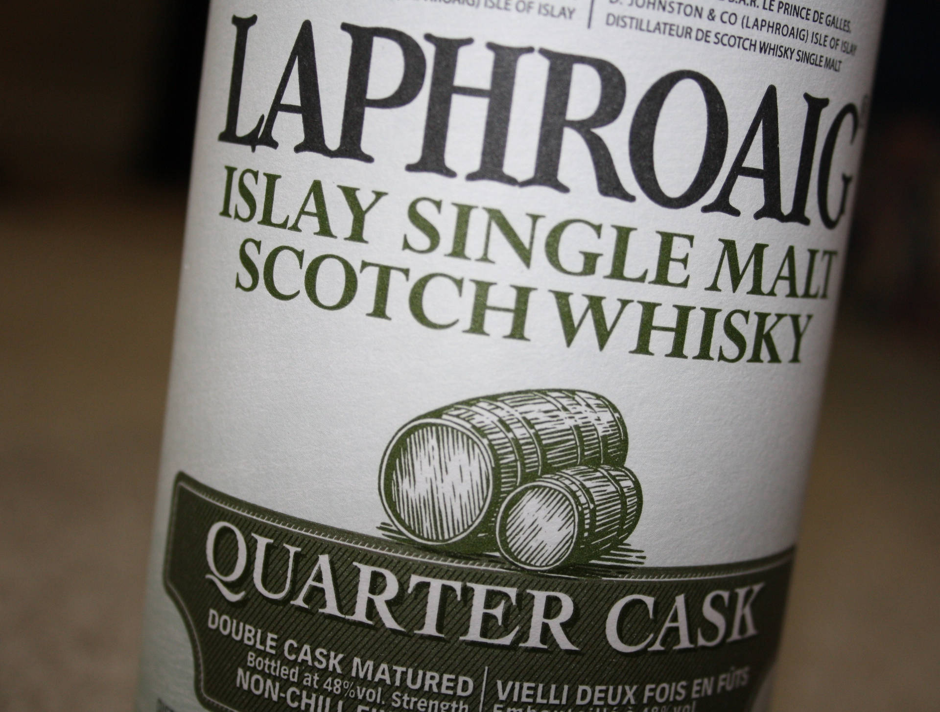 Laphroaig 威士忌酒瓶標籤，帶有 quarter cask 和木桶插圖。