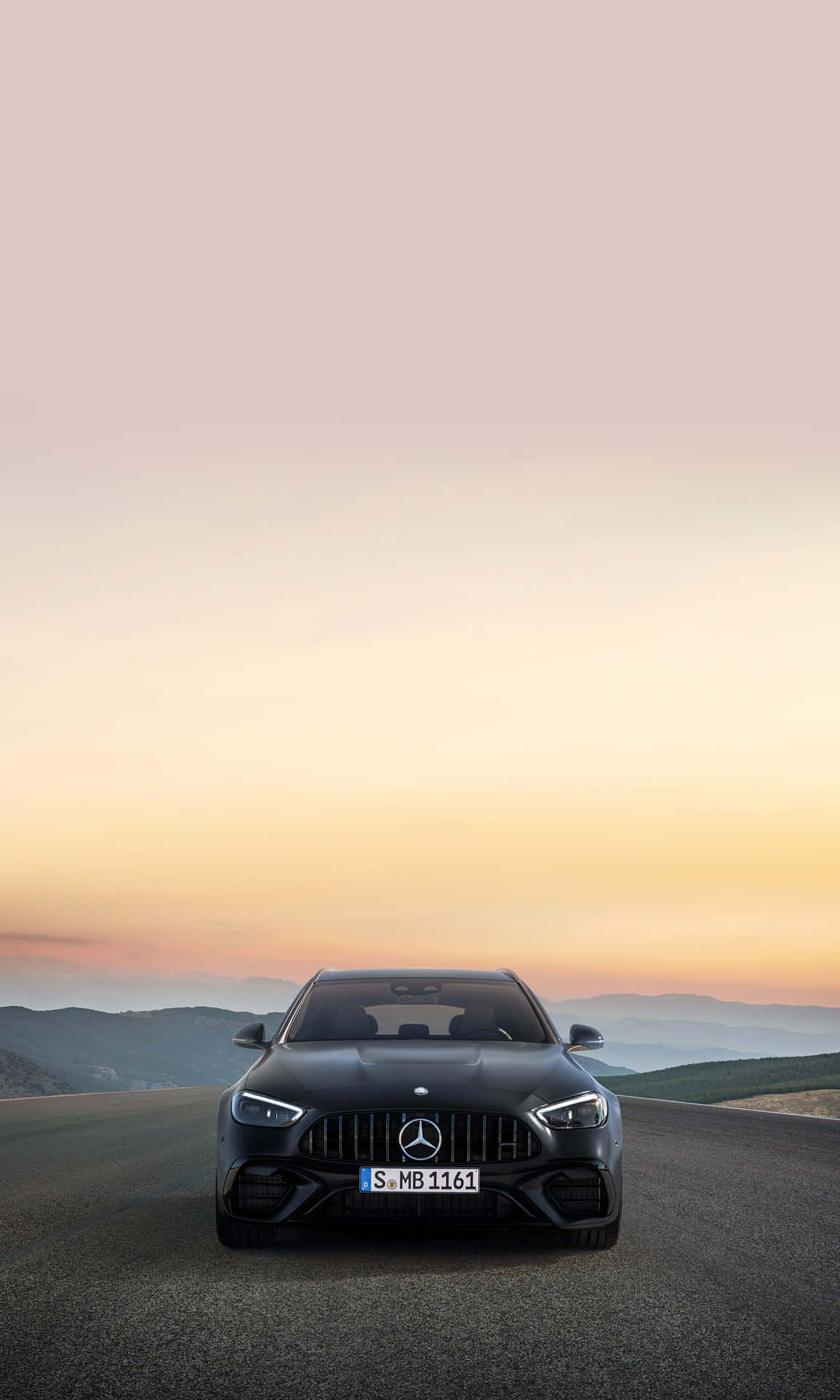黑色Mercedes-AMG跑車在山路夕陽下