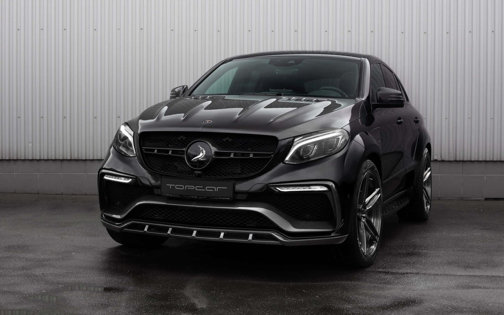 啞光黑色改裝梅賽德斯-AMG GLE Coupe，帶有碳纖維細節，停在潮濕的路面上。