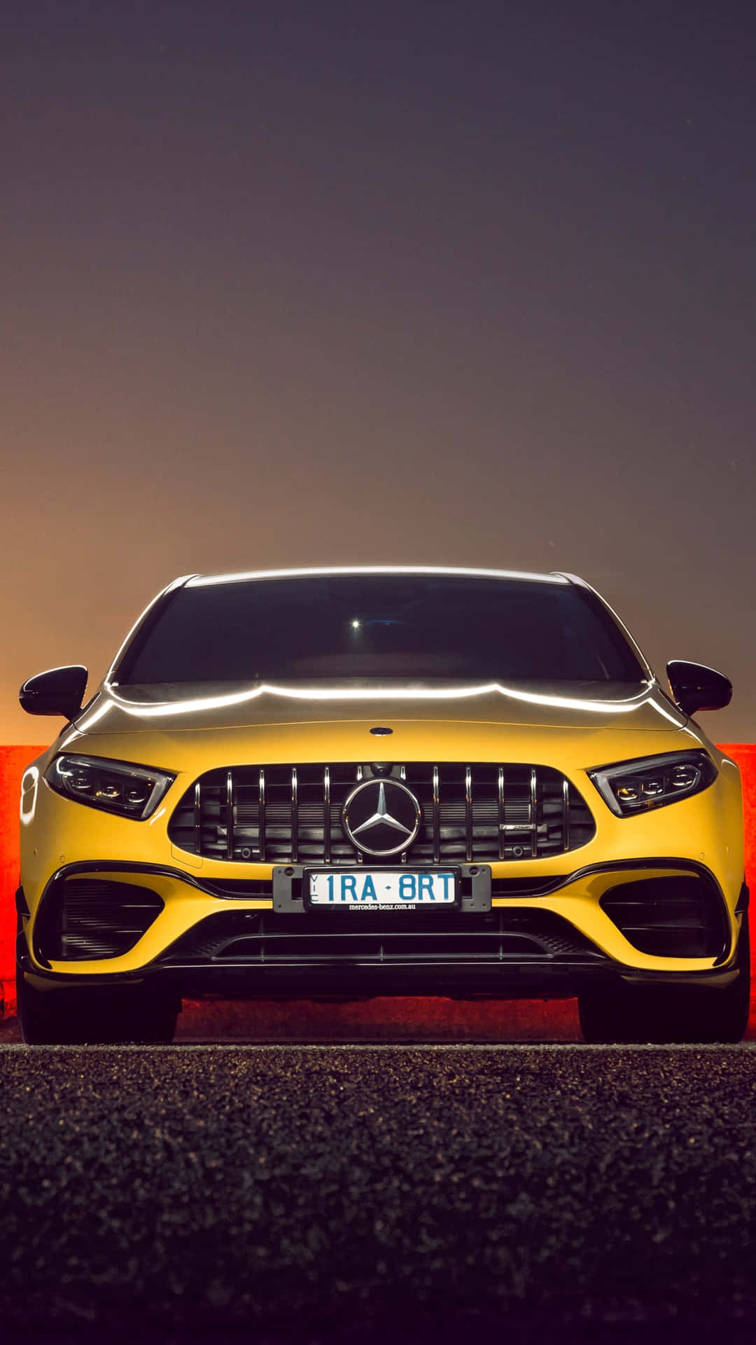 夜間黃色Mercedes-AMG跑車，帶有發光的頭燈和水箱護罩。