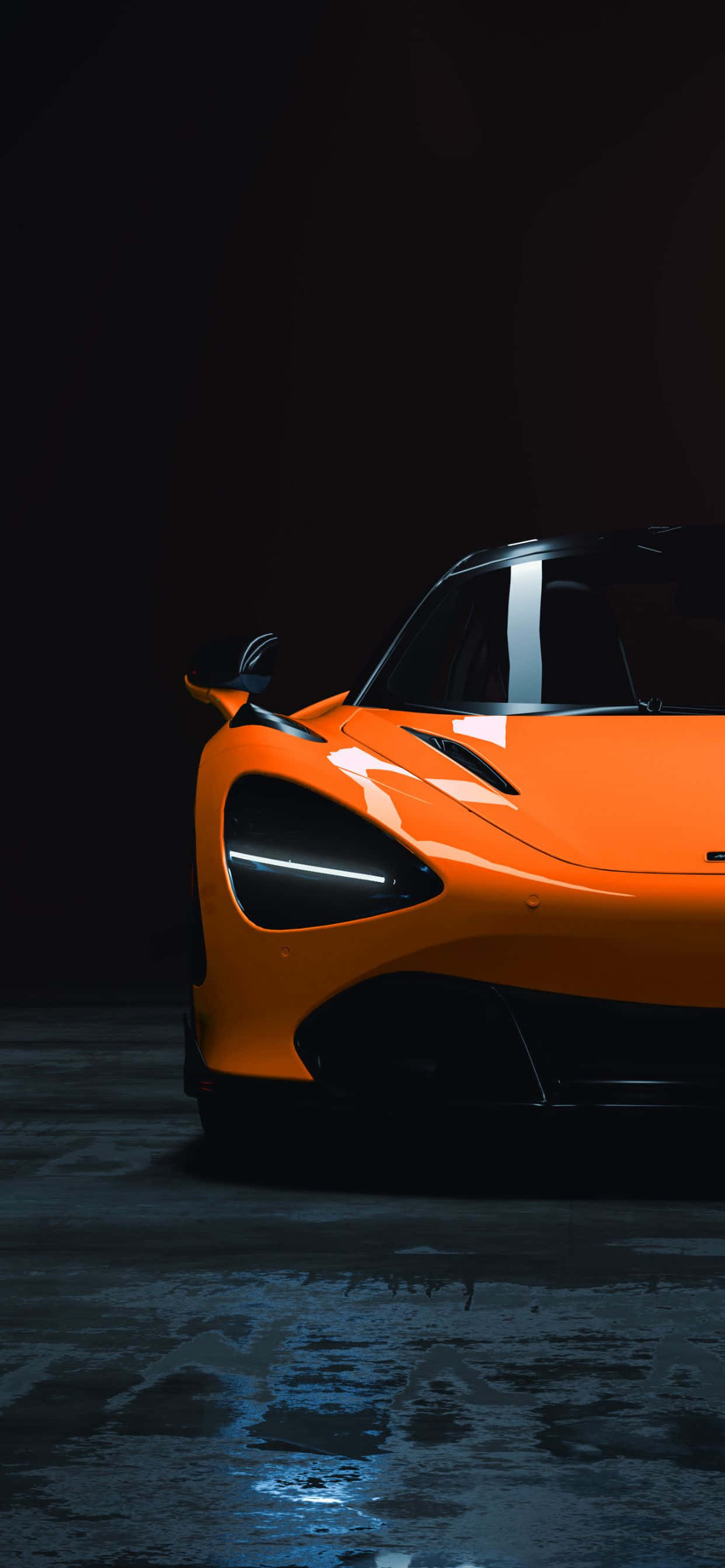 奢華的頂峰組合：iPhone XS Max 與 McLaren 720S 壁紙 — 一輛充滿活力的橙色跑車在戲劇性的燈光下，在黑暗潮濕的混凝土地板上發光。