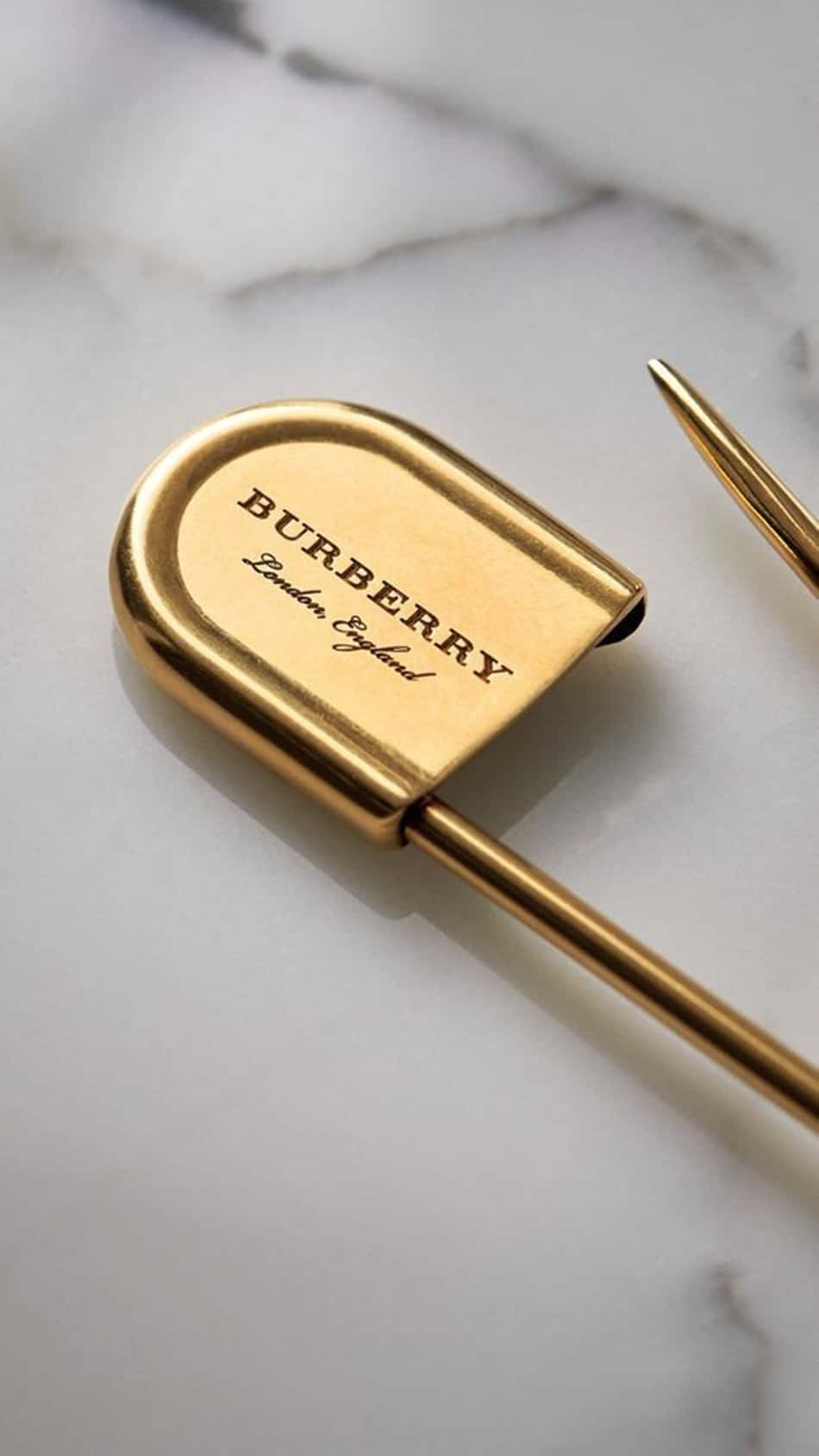 白色大理石背景上的金色 Burberry 鋼筆