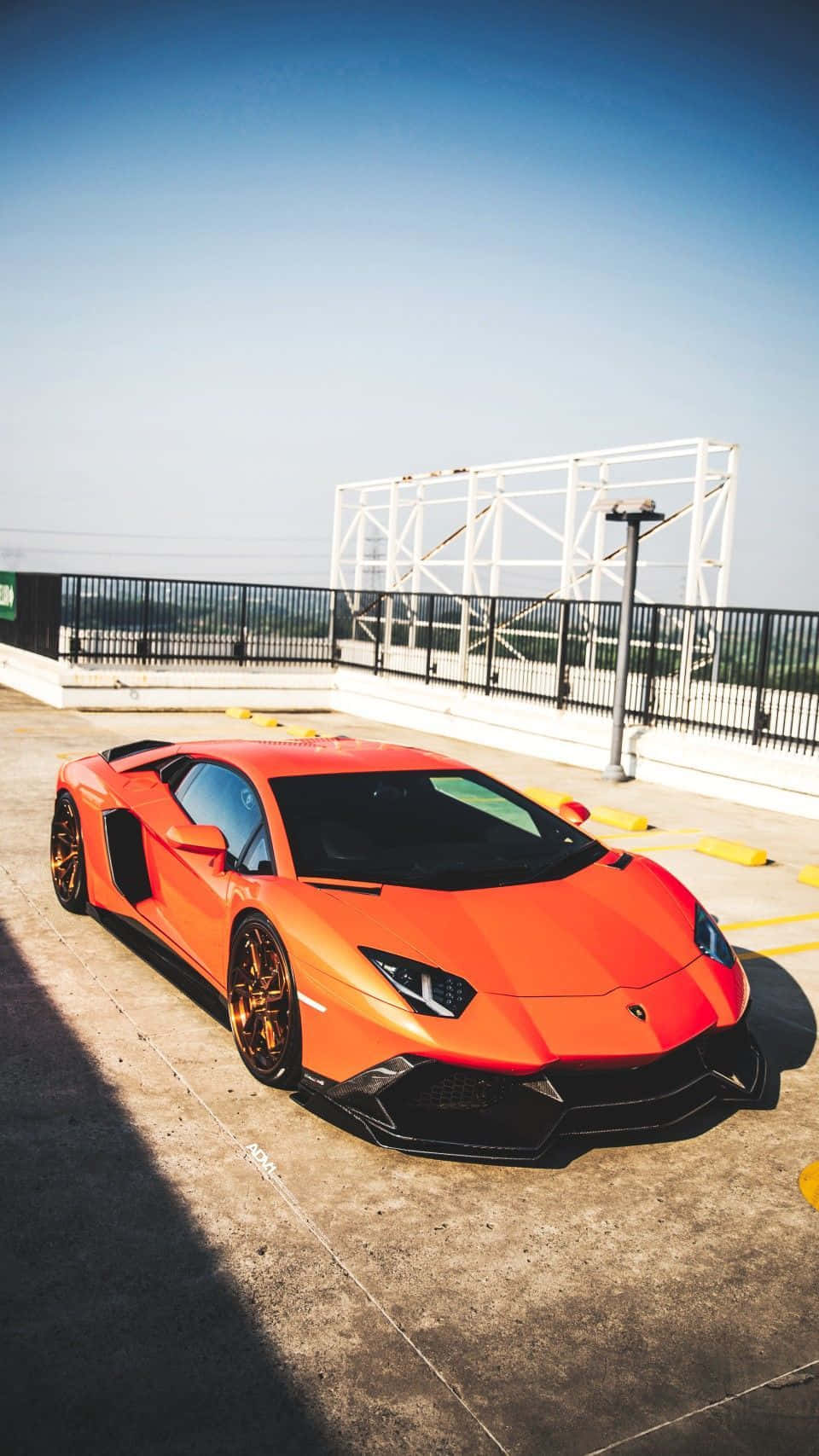 橙色林寶堅尼Aventador在烈日下停泊在天台停車場。