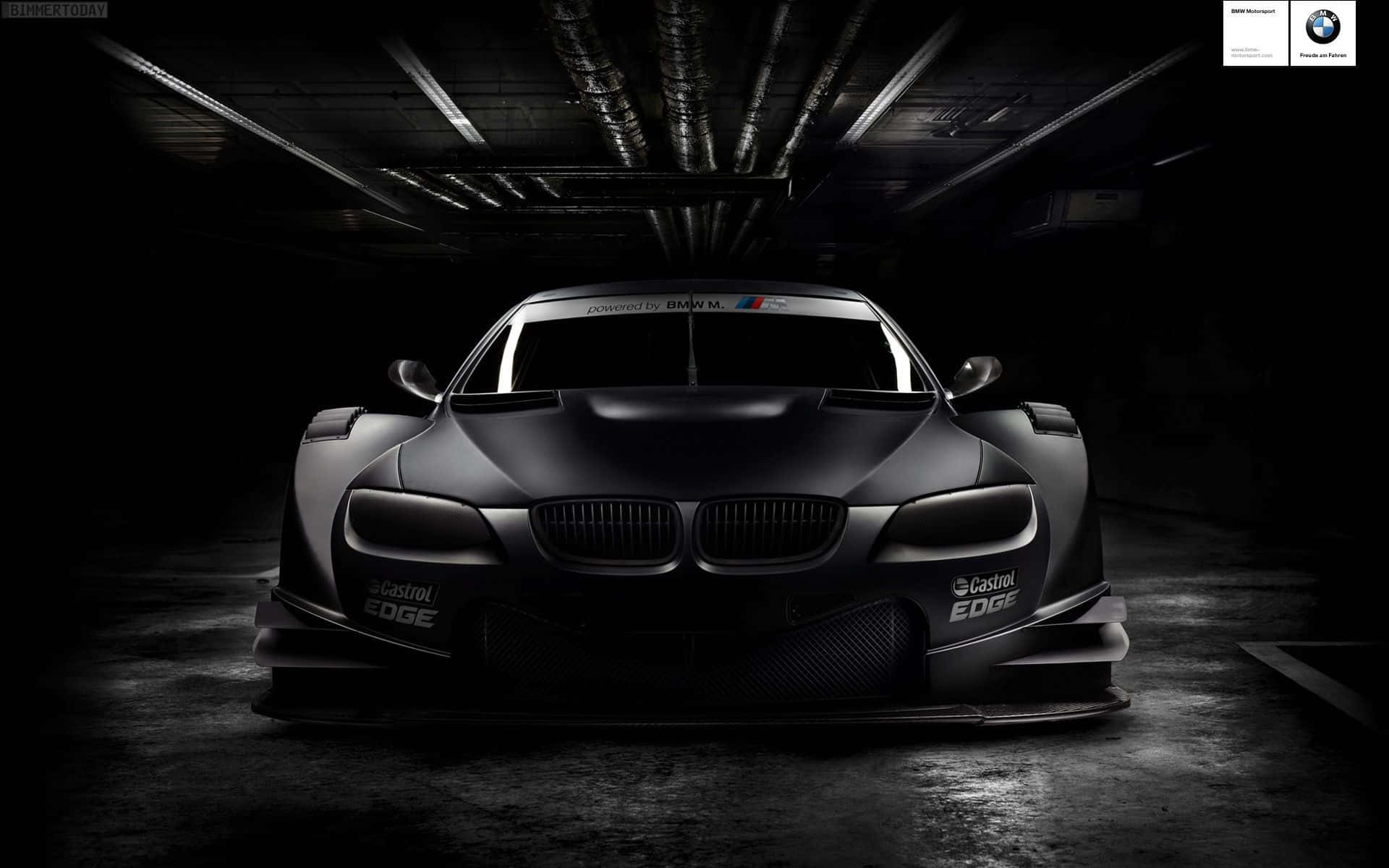 啞光黑色BMW賽車在黑暗的工業車庫中，帶有聚焦照明。