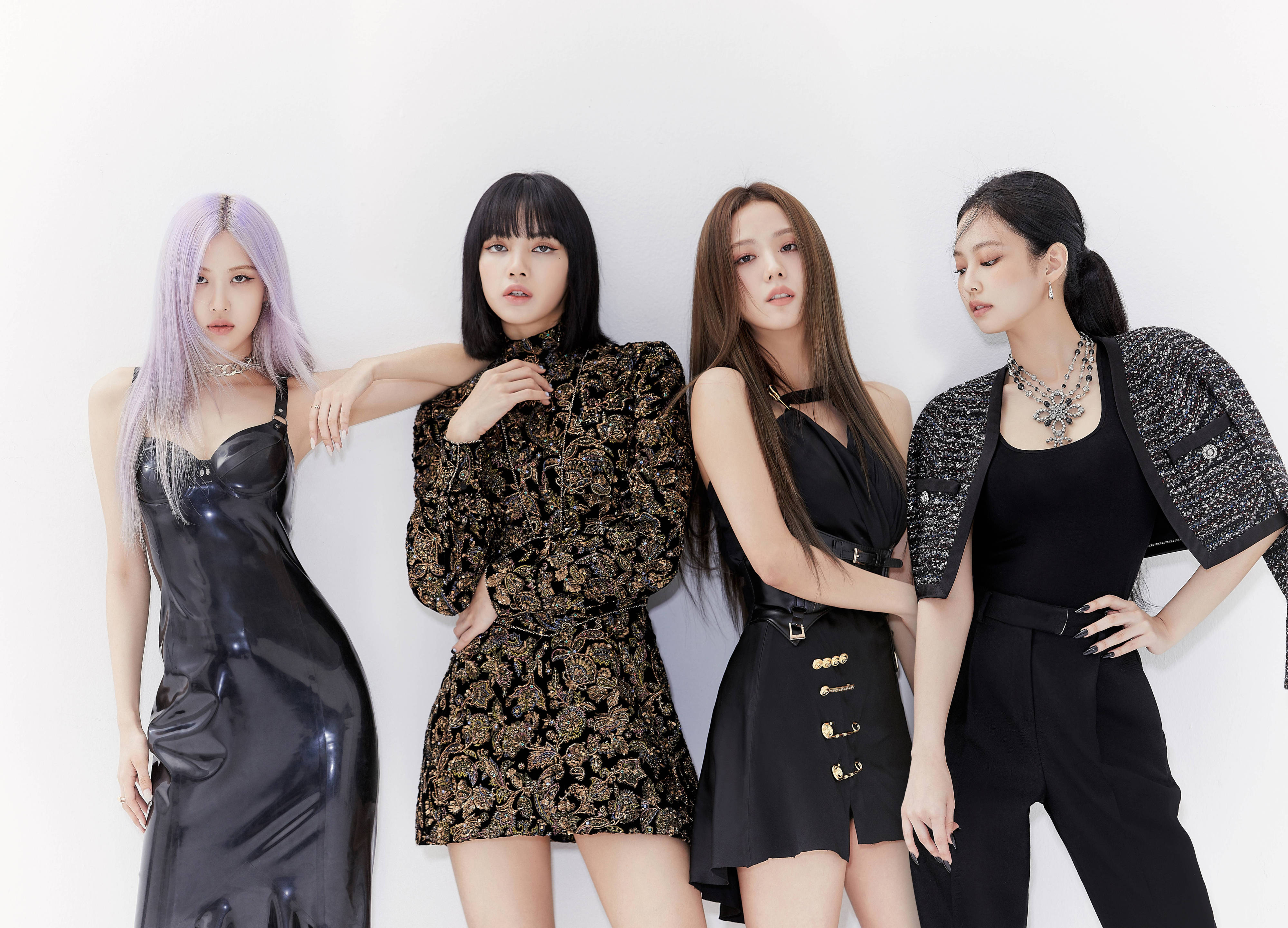 奢華造型Blackpink桌面壁紙 壁紙 — 四位時尚女性身穿黑色服裝，在純白色背景前以戲劇性燈光自信地擺姿勢。