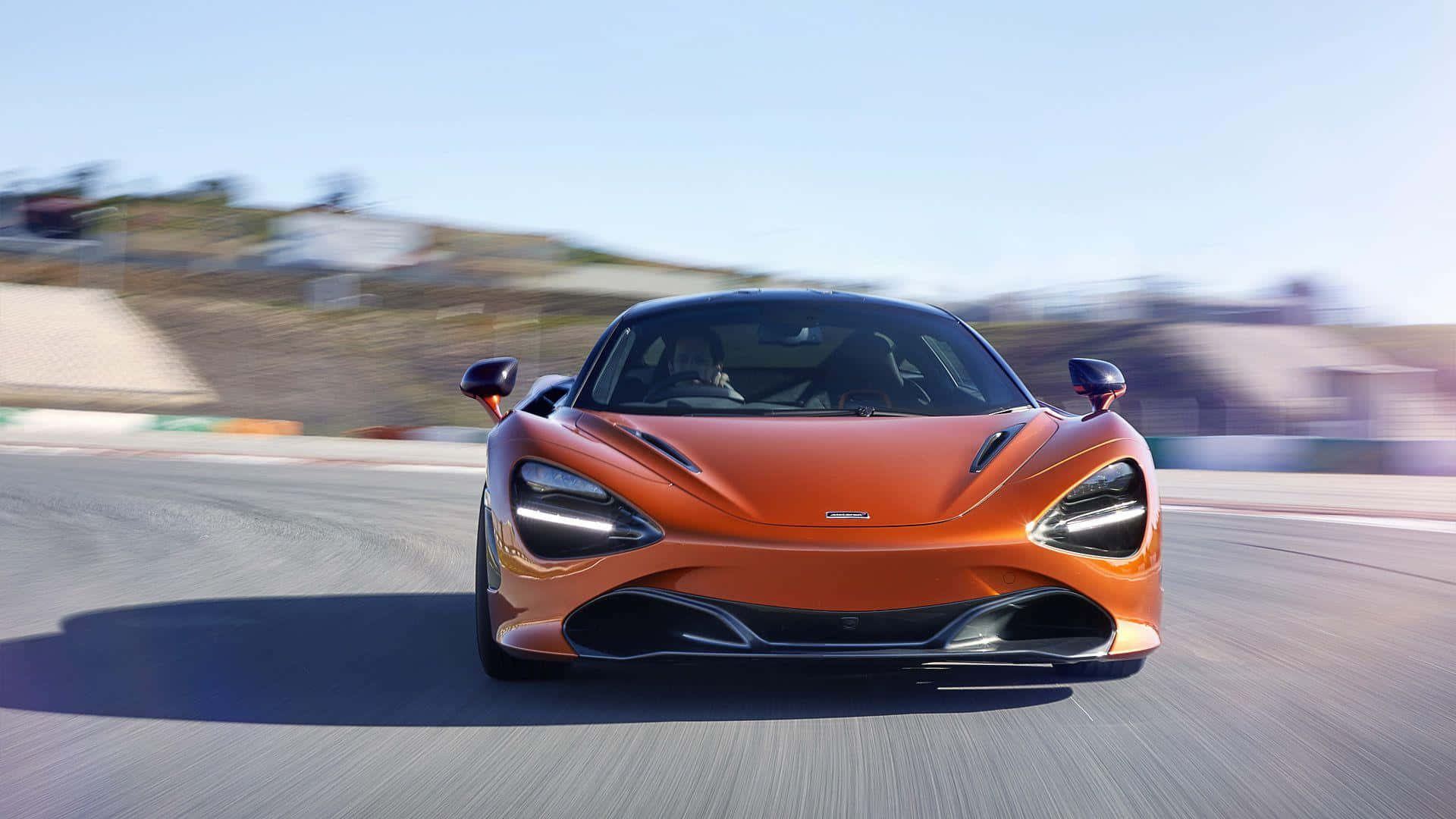 橙色McLaren賽車在賽道上疾馳，帶有動態模糊效果