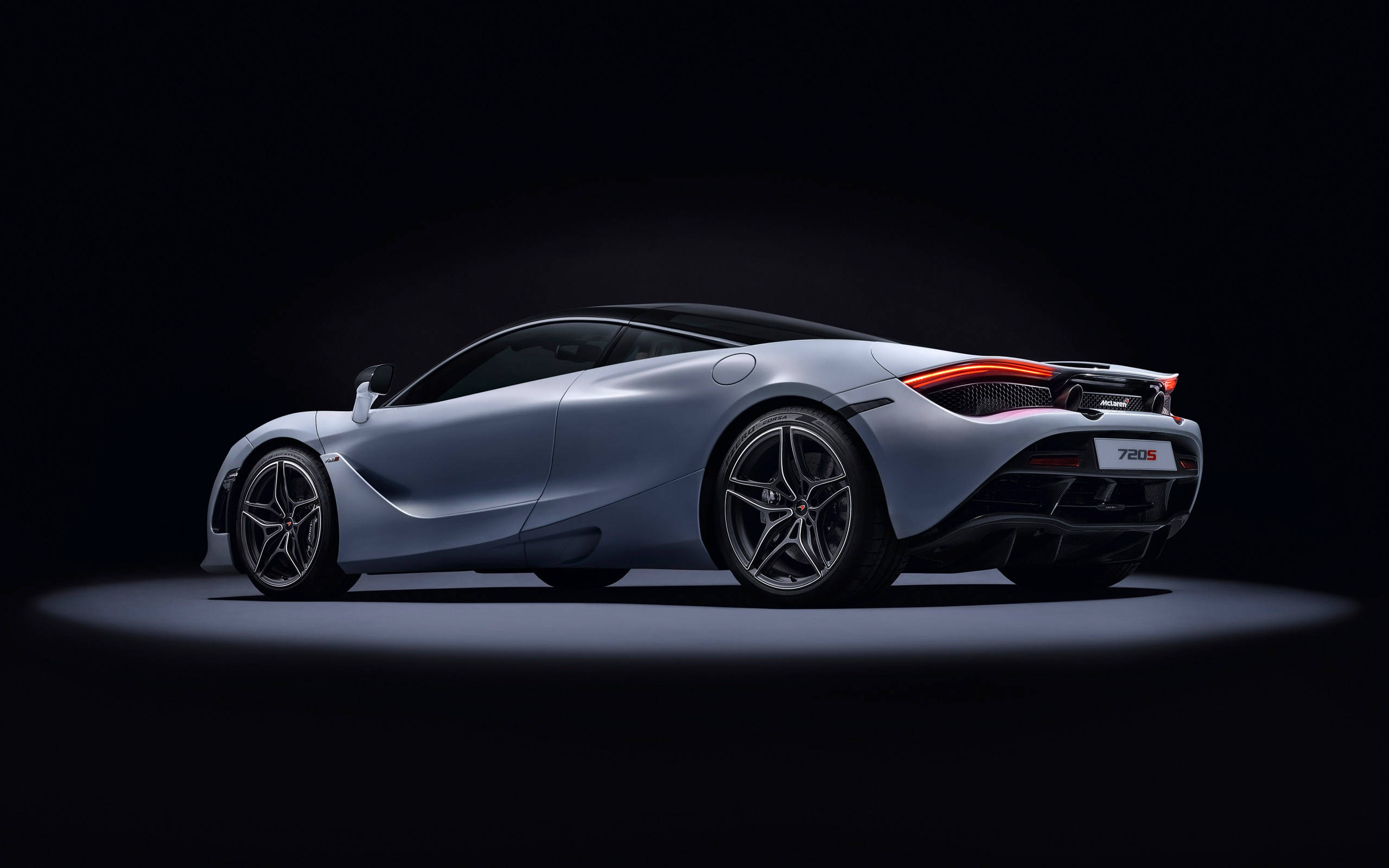 奢華銀色麥拉倫720s 4K解析度 壁紙 — 一輛時尚的銀色McLaren 720S跑車在黑色工作室背景下，在聚光燈下閃耀，紅色尾燈亮起。