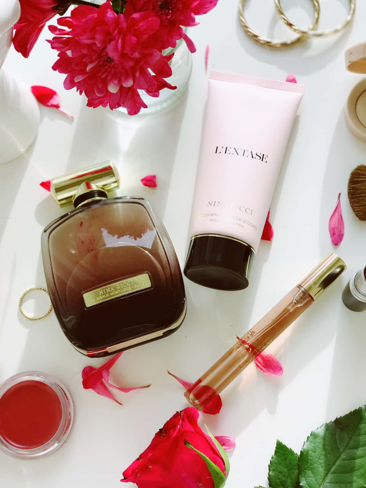 Spring Perfume 桌布 壁紙 — 奢華香水及護膚產品，配以鮮豔粉紅花朵及金色首飾，在明亮的白色表面上藝術地擺放。